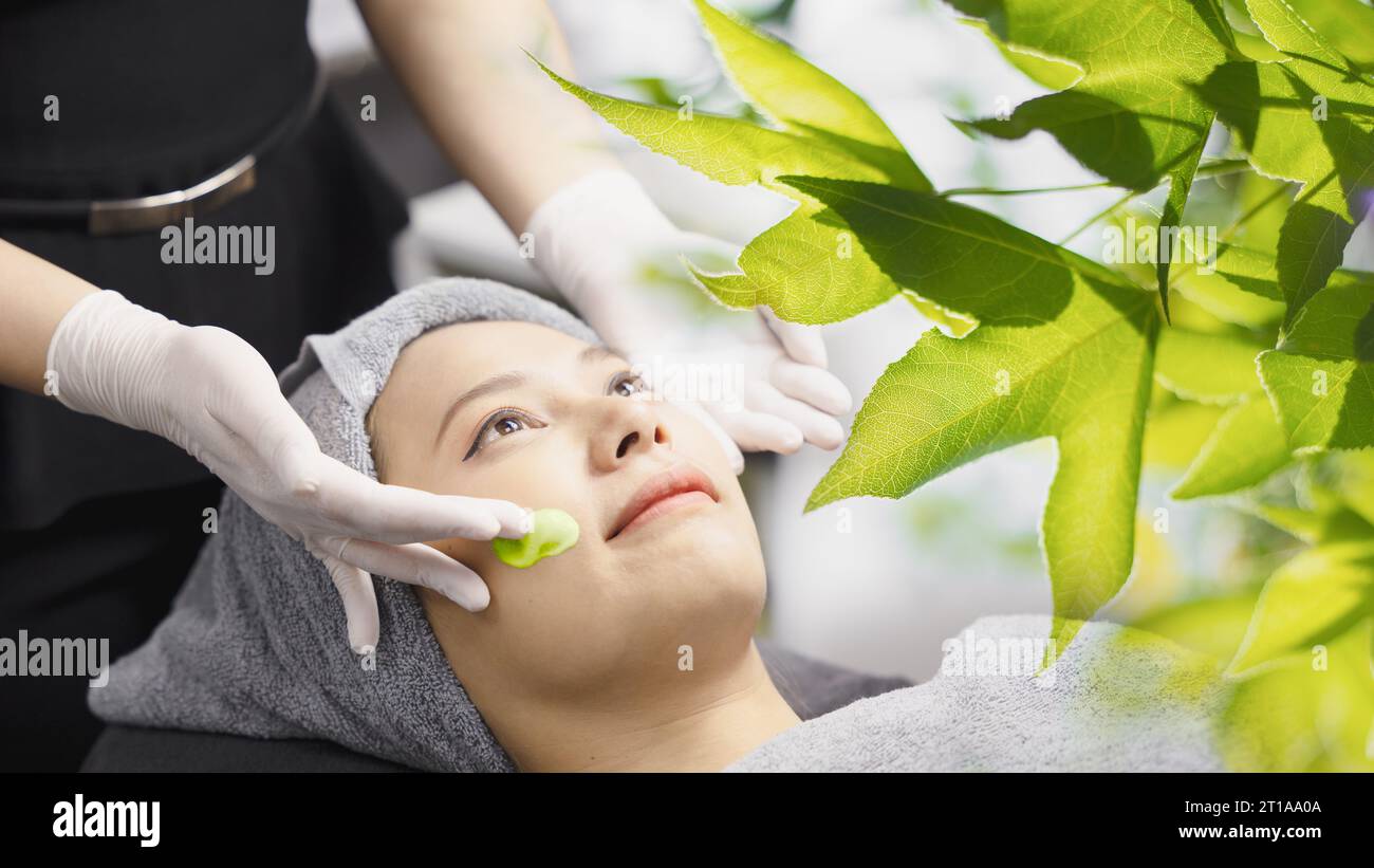 Le traitement du visage vert nature et le massage spa de la peau du visage avec le produit de crème d'essence naturelle éliminent les rides femme look plus jeune anti-vieillissement Banque D'Images