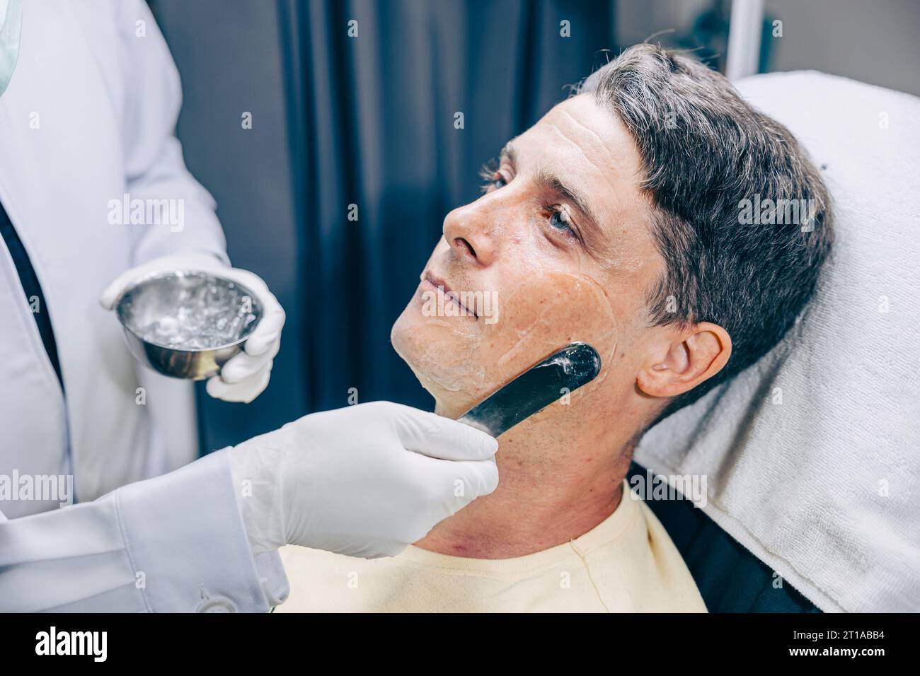 Médecin de la peau appliquant RF Thermage Gel ou traitement ultrasonique Conductive Gel traitement facial Skincare homme adulte réduisent les rides à la clinique anti-vieillissement Banque D'Images