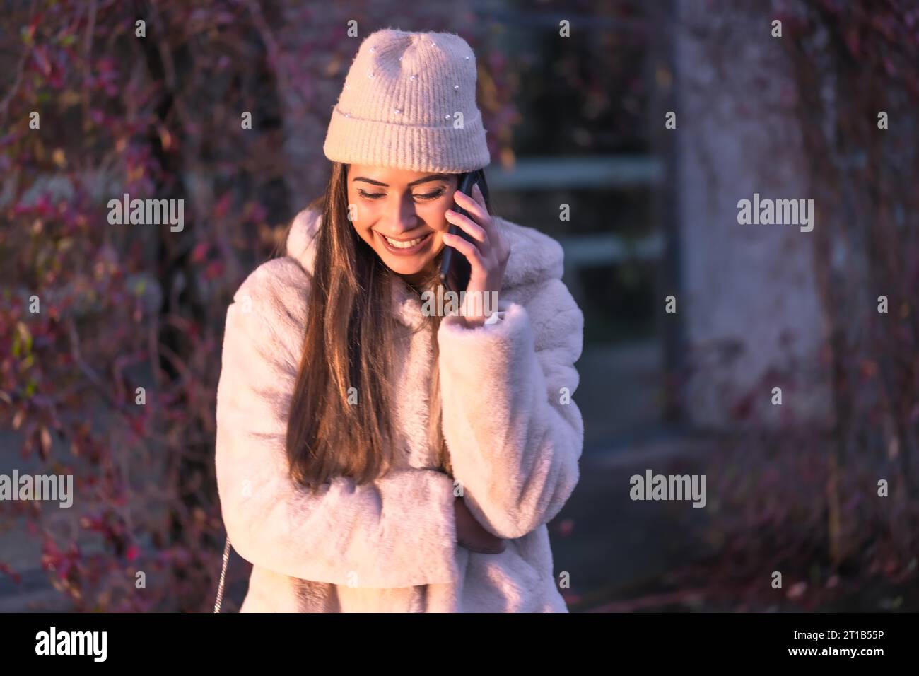 Jeune jolie brunette caucasienne marchant dans la ville en hiver, portant un pull en laine rose Banque D'Images