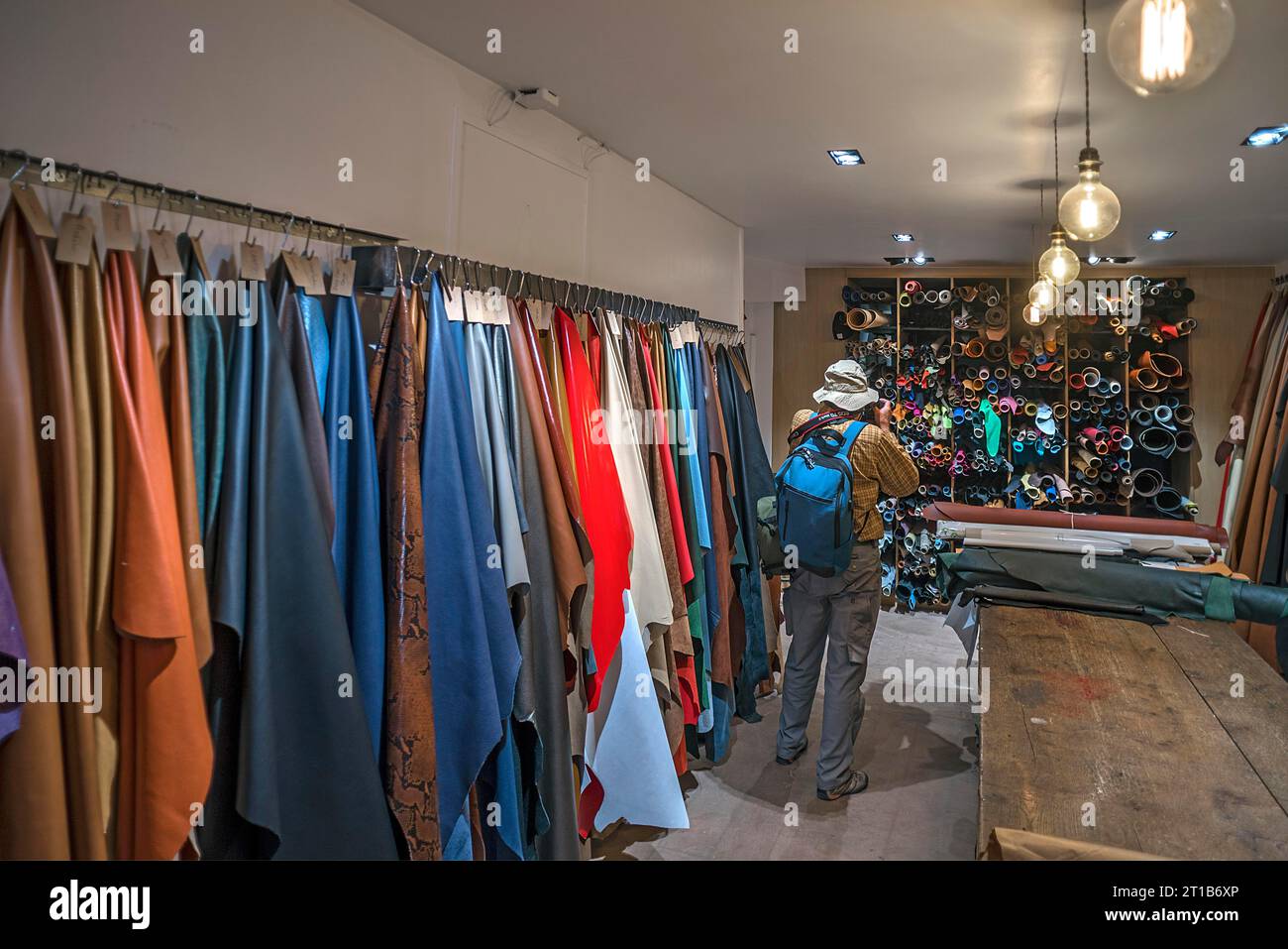 Touriste prenant des photos des étagères en cuir dans une sellerie avec permission, Paris, France Banque D'Images