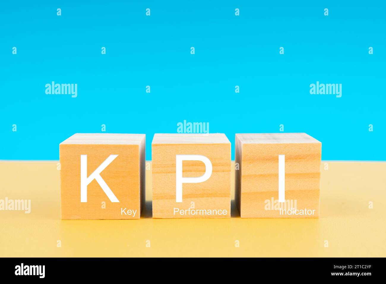 KPI : indicateur clé de performance en cubes en bois sur fond jaune et bleu. Concepts des objectifs commerciaux. Banque D'Images