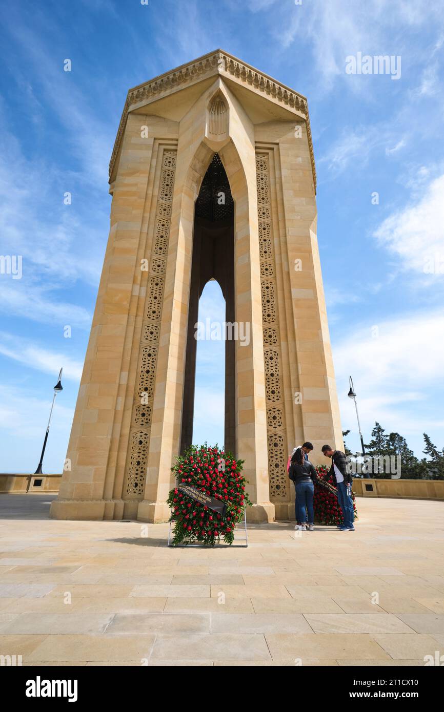 Fleurs commémoratives placées à la base de l'imposant et emblématique monument Shahidlar. Au cimetière militaire et mémorial Highland Park à Bakou, Azerbaïdjan. Banque D'Images