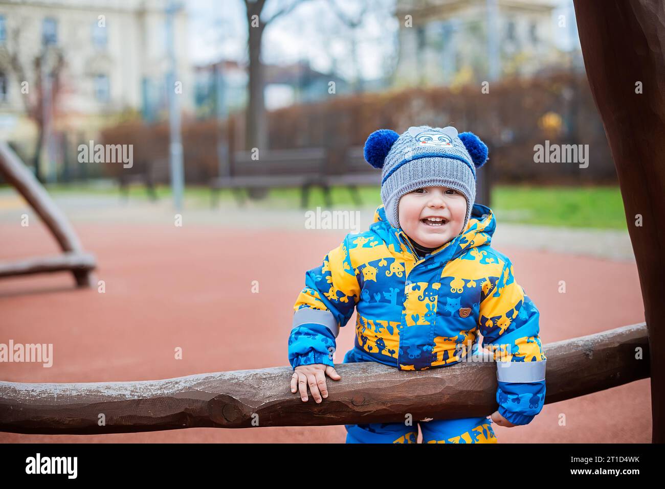 Petit garçon dans une veste bleue sur la cour de récréation dans le parc. Banque D'Images