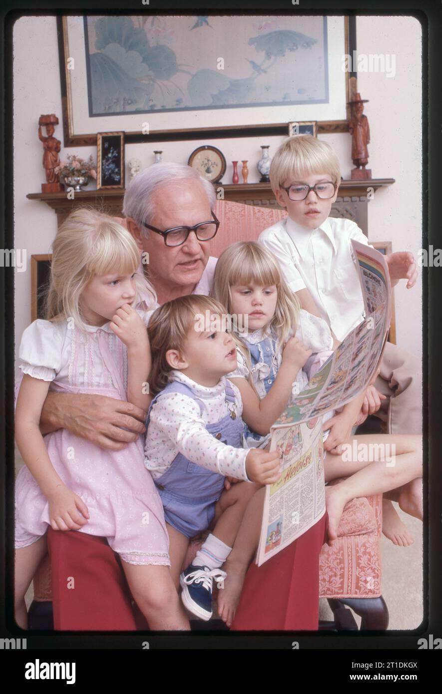 Le journaliste Jack Anderson, chroniqueur de journal décédé, photographié chez lui. Il est décrit comme un pionnier du journalisme d'investigation moderne. Ici, dans son salon, il lit les bandes dessinées à 4 petits-enfants Banque D'Images