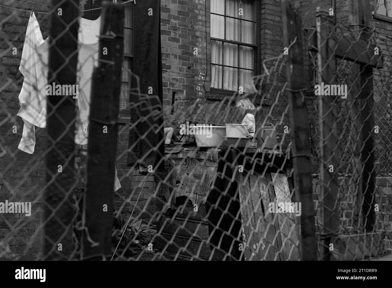 Frère et sœur jouant dans l'arrière-cour de leur maison mitoyenne victorienne pendant le nettoyage des bidonvilles de St ann's, Nottingham, Angleterre. 1969-1972 Banque D'Images