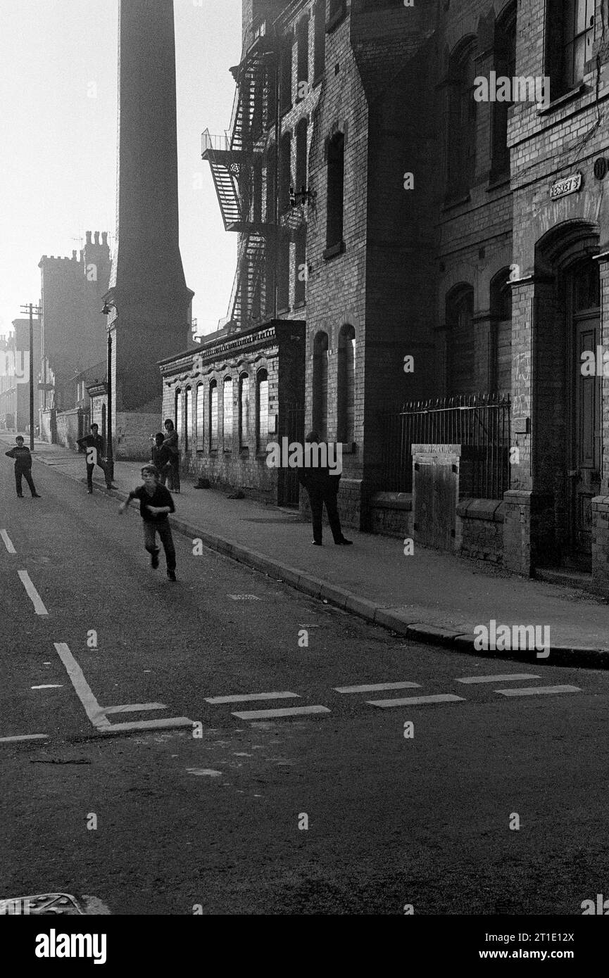 Groupe de garçons jouant au football devant l'usine Cooper and Roe sur Heskey Street, St ann's, Nottingham pendant le déminage et la démolition des bidonvilles 1969-72 Banque D'Images