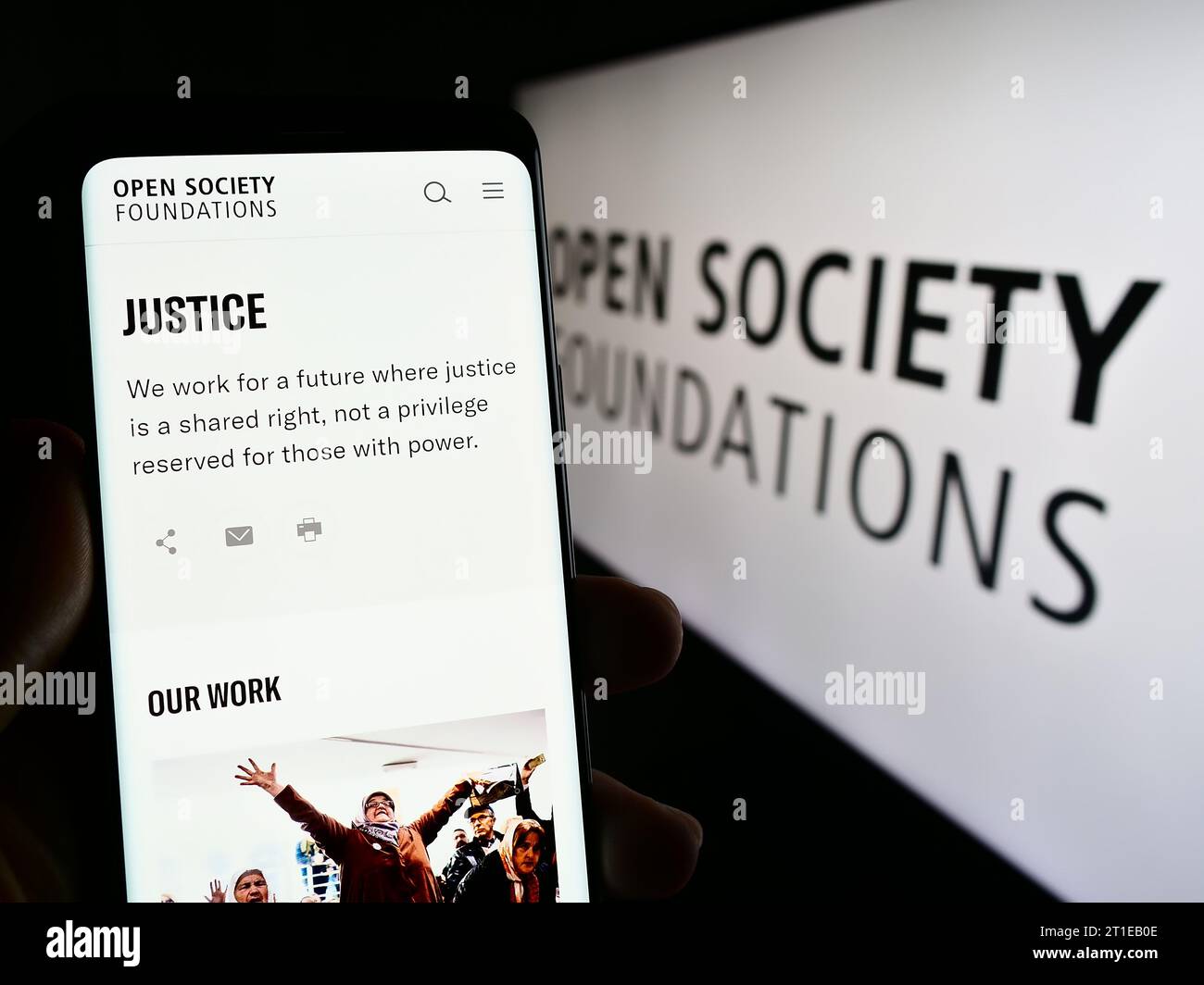 Personne tenant un téléphone cellulaire avec la page Web de l'organisation Open Society Foundations (OSF) devant le logo. Concentrez-vous sur le centre de l'écran du téléphone. Banque D'Images