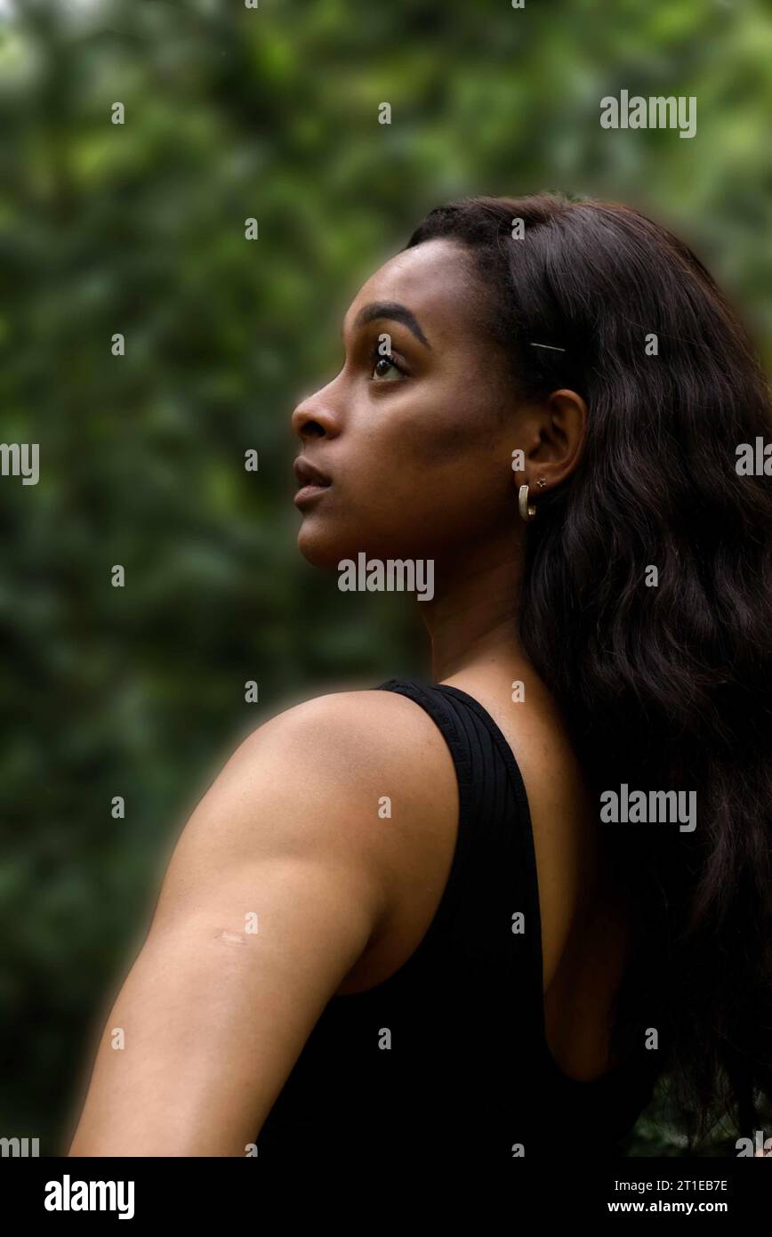 jeune femme noire portant un débardeur noir et un jean dans les bois Banque D'Images