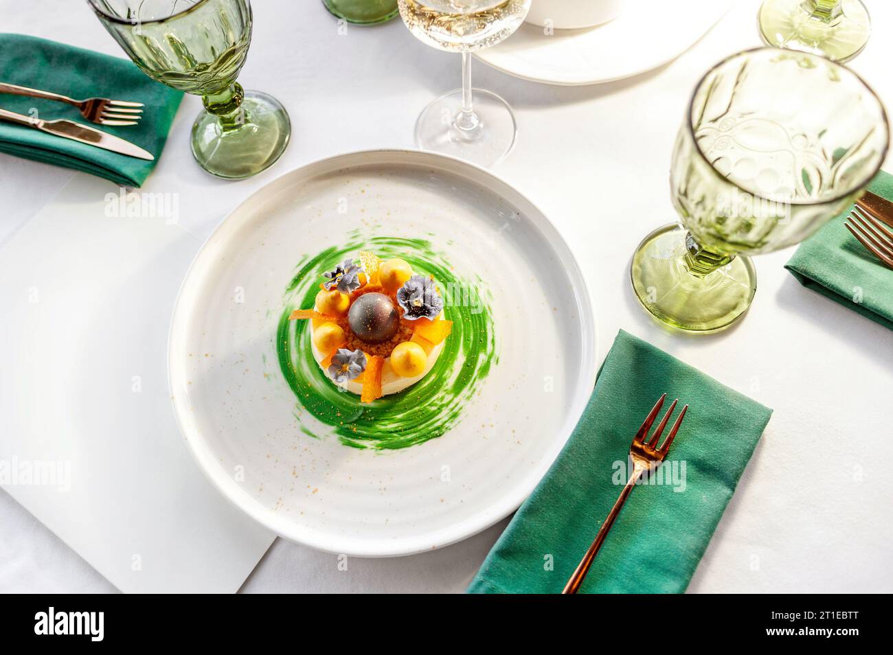 Dessert gourmand avec meringue à la mangue sur une assiette blanche sur une table dans un restaurant Banque D'Images