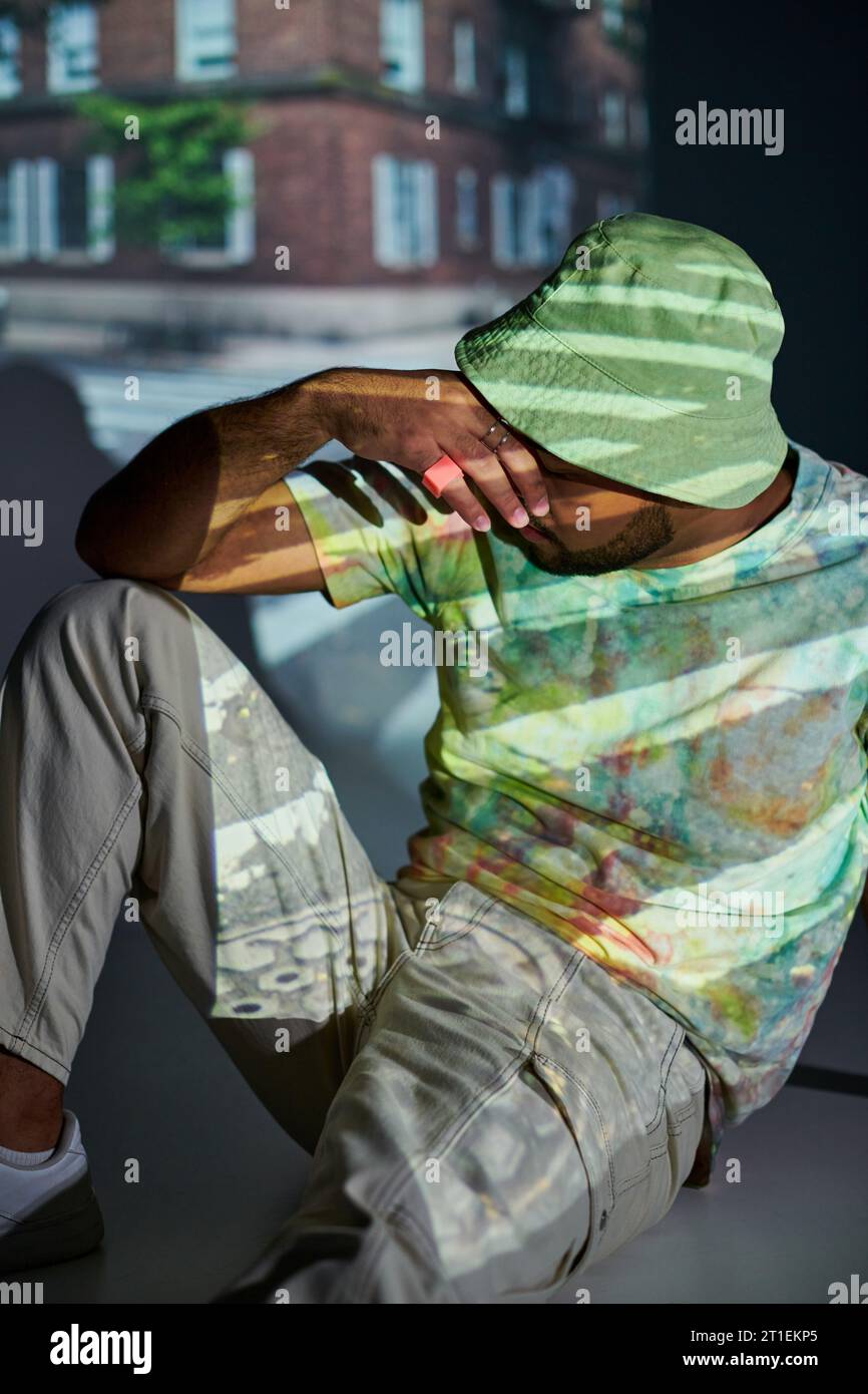 bon modèle masculin afro-américain posant avec la main fermant son visage, concept de mode Banque D'Images