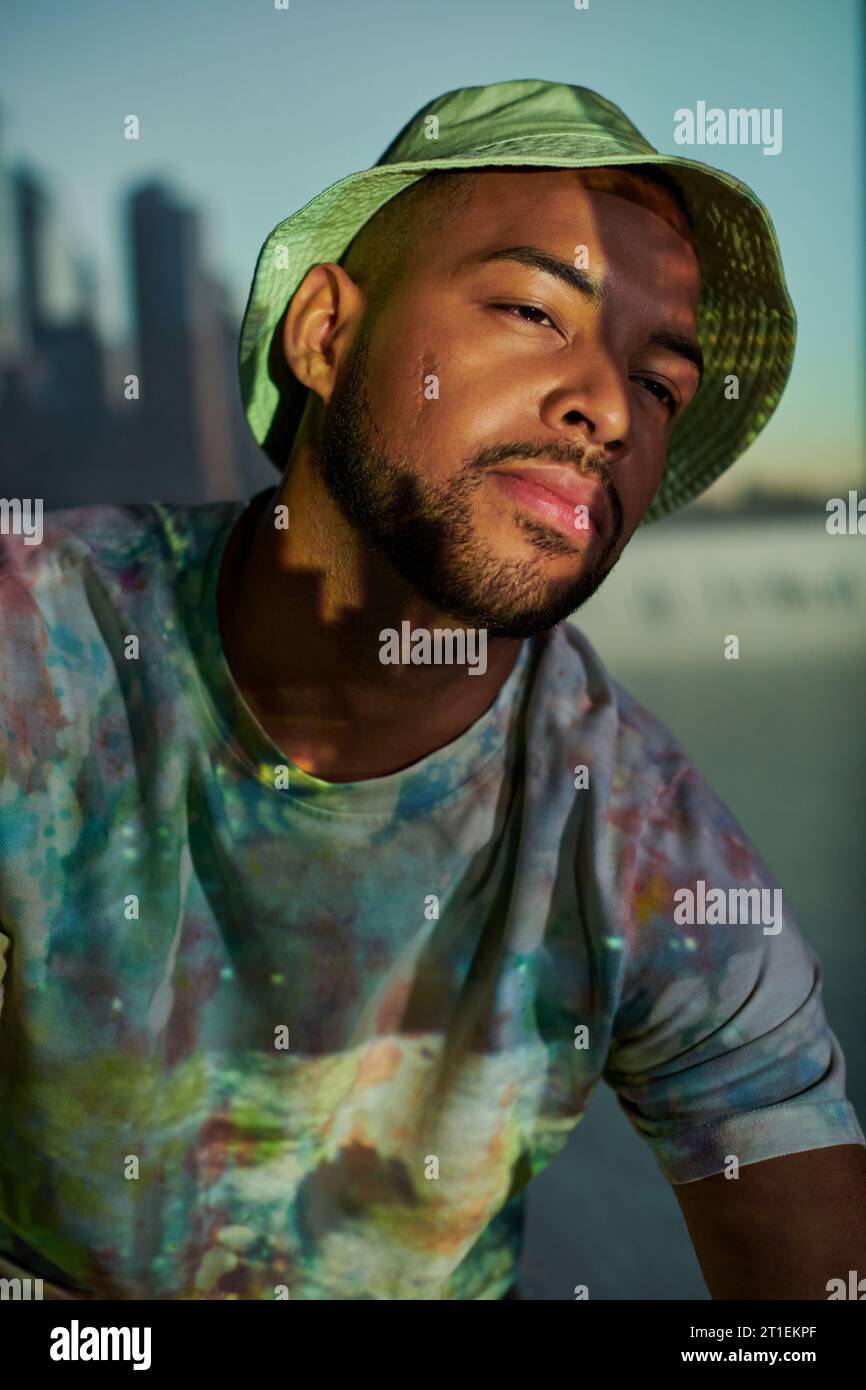 portrait de beau modèle masculin élégant au panama dans des lumières de projecteur numérique, concept de mode Banque D'Images