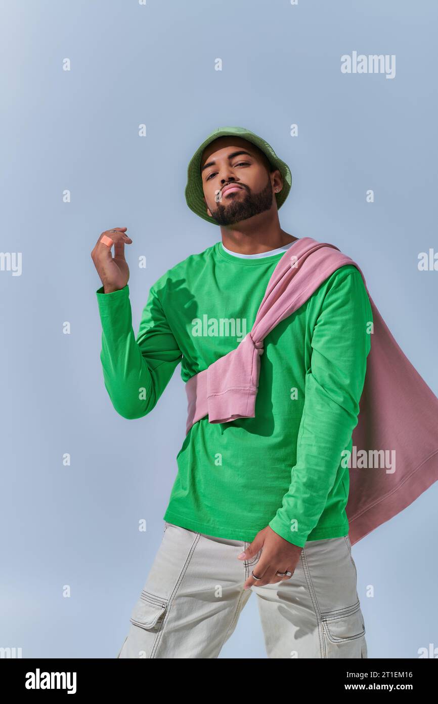 beau modèle masculin afro-américain dans la tenue de rue à la mode dansant sur la caméra, concept de mode Banque D'Images