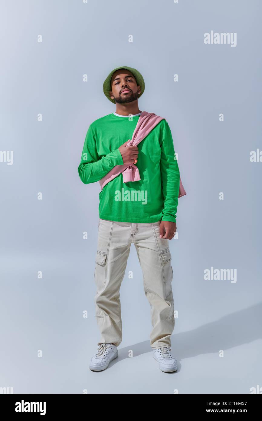 jeune modèle masculin tendance en tenue décontractée avec sweat-shirt attaché sur ses épaules, concept de mode Banque D'Images