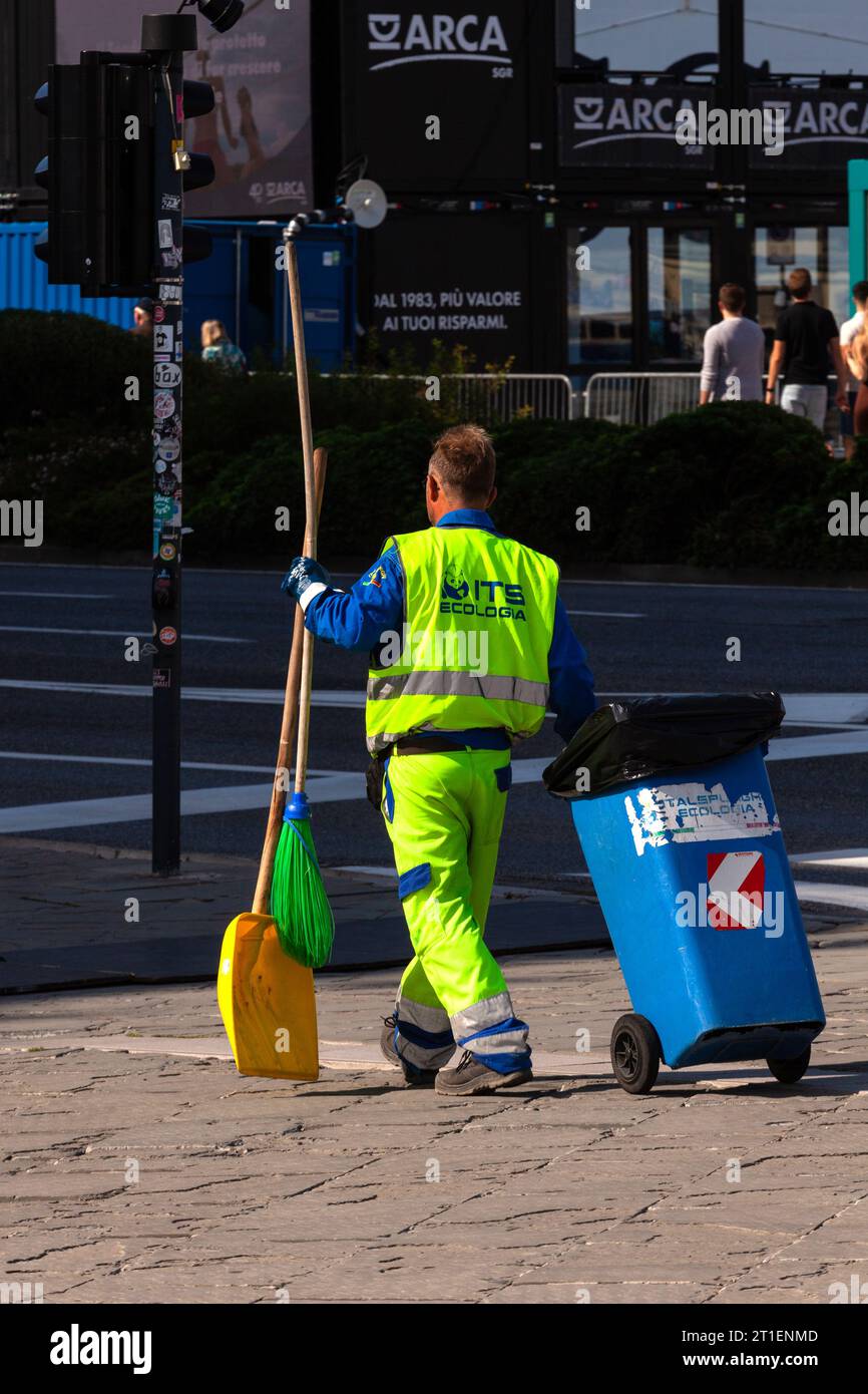 Trieste, Italie – 30 septembre 2023 : un homme vêtu d'uniforme jaune ramasse des ordures, nettoie les rues. Dépoussiéreur, dépoussiéreur, poubelle, cendres Banque D'Images