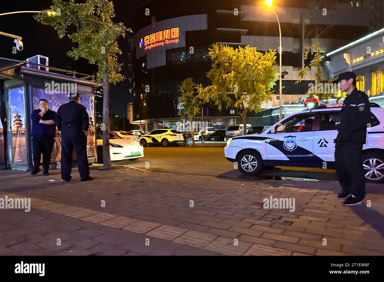 Chinese police officers and security personnel stand near what is believed to be the site of a stabbing incident in Beijing, Friday, Oct. 13, 2023. A 50-year-old Israeli man who works at the Israeli Embassy in Beijing was stabbed Friday in front of a supermarket, Chinese police and the Israeli government said. (AP Photo/Ng Han Guan) Banque D'Images