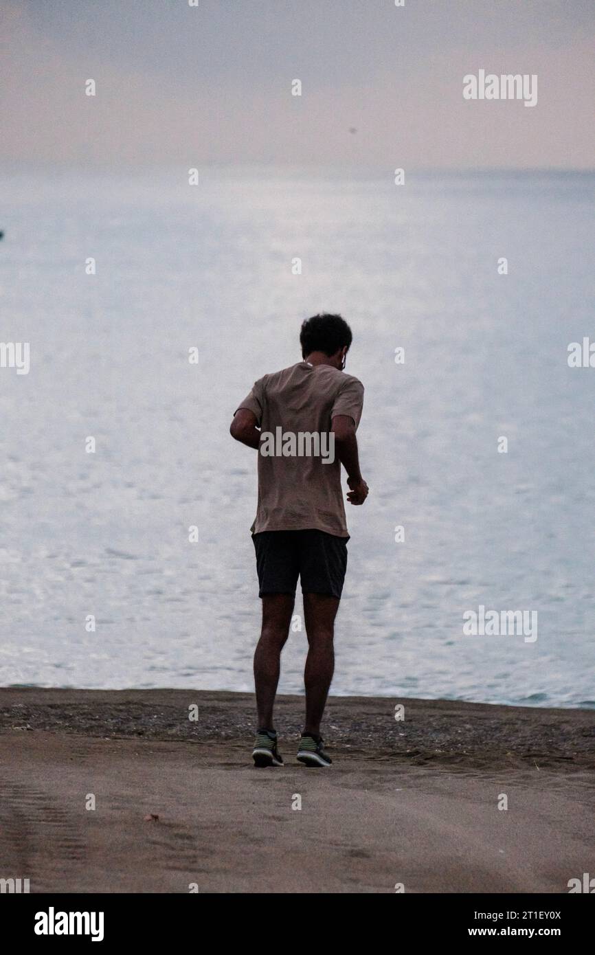 Lever du soleil sur la promenade, Malaga, lever du soleil, homme faisant du sport dans le sable, regardant la mer Banque D'Images