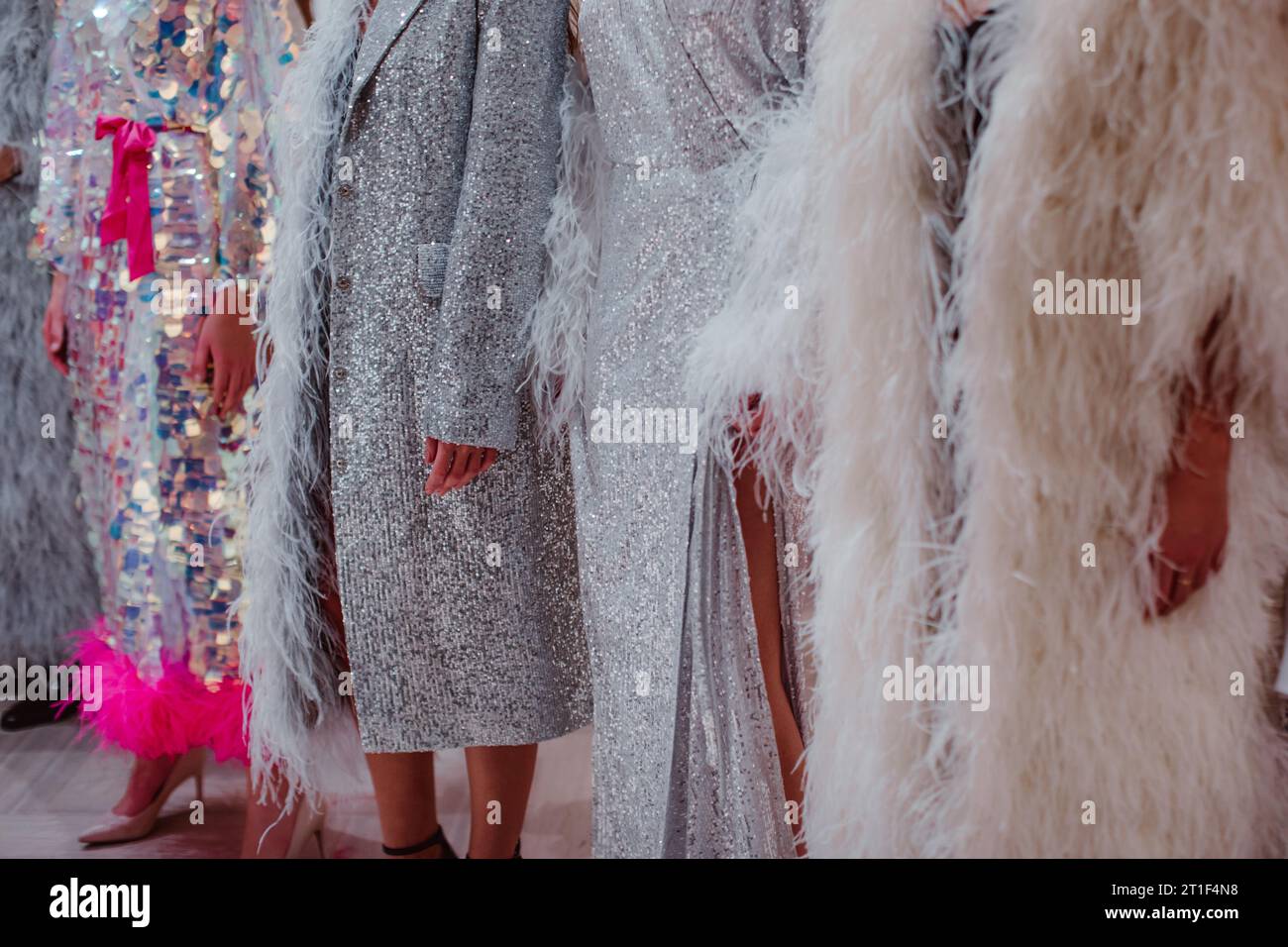 Silhouettes de mannequins sur les coulisses habillées dans un long boudoir haute couture habillé de tenues. Préparation avant le défilé de mode Banque D'Images