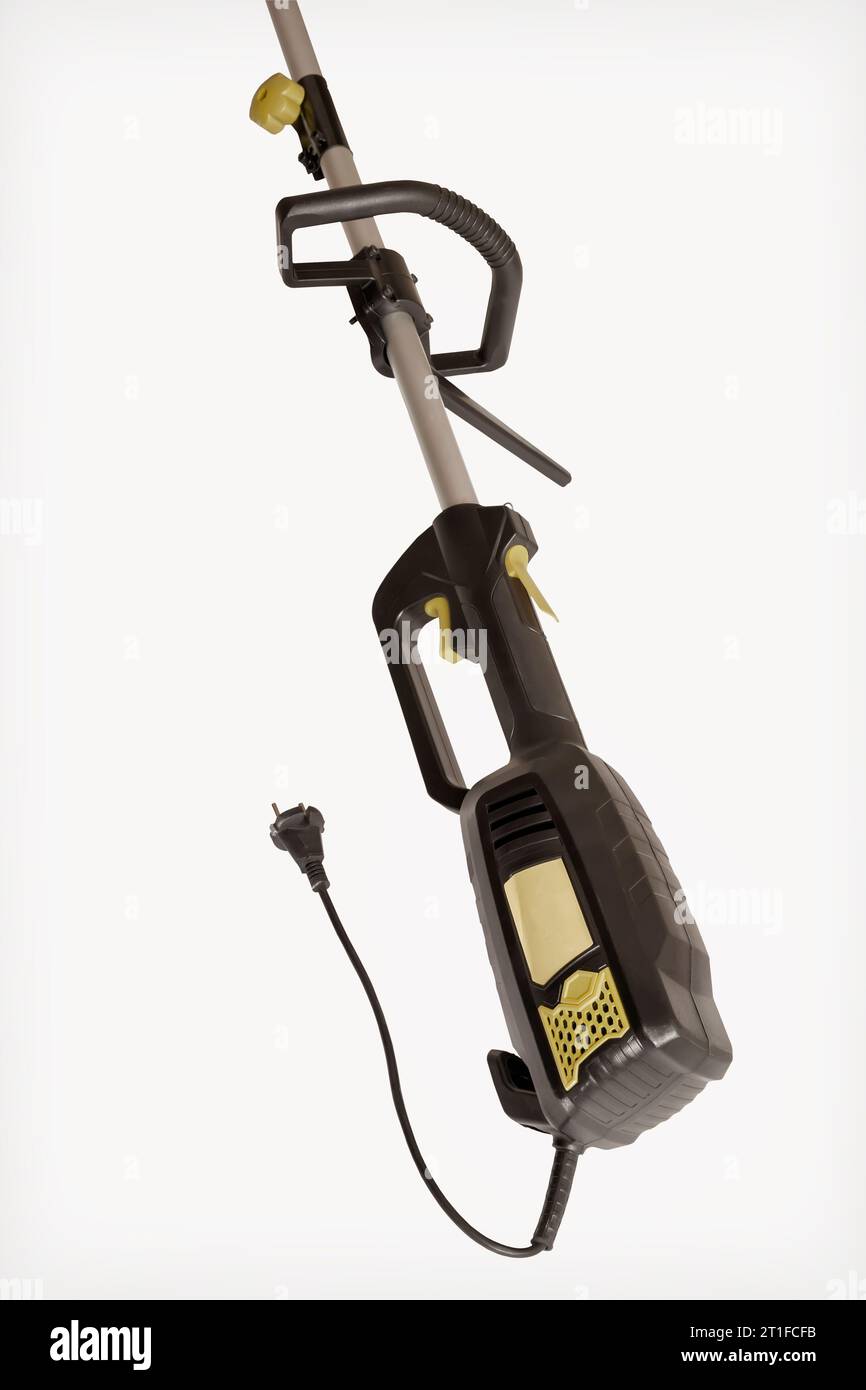 Appareils ménagers : tondeuse-coupe électrique pour tondre les pelouses. Fragment d'un mécanisme avec un moteur électrique. Présenté sur fond blanc, Banque D'Images