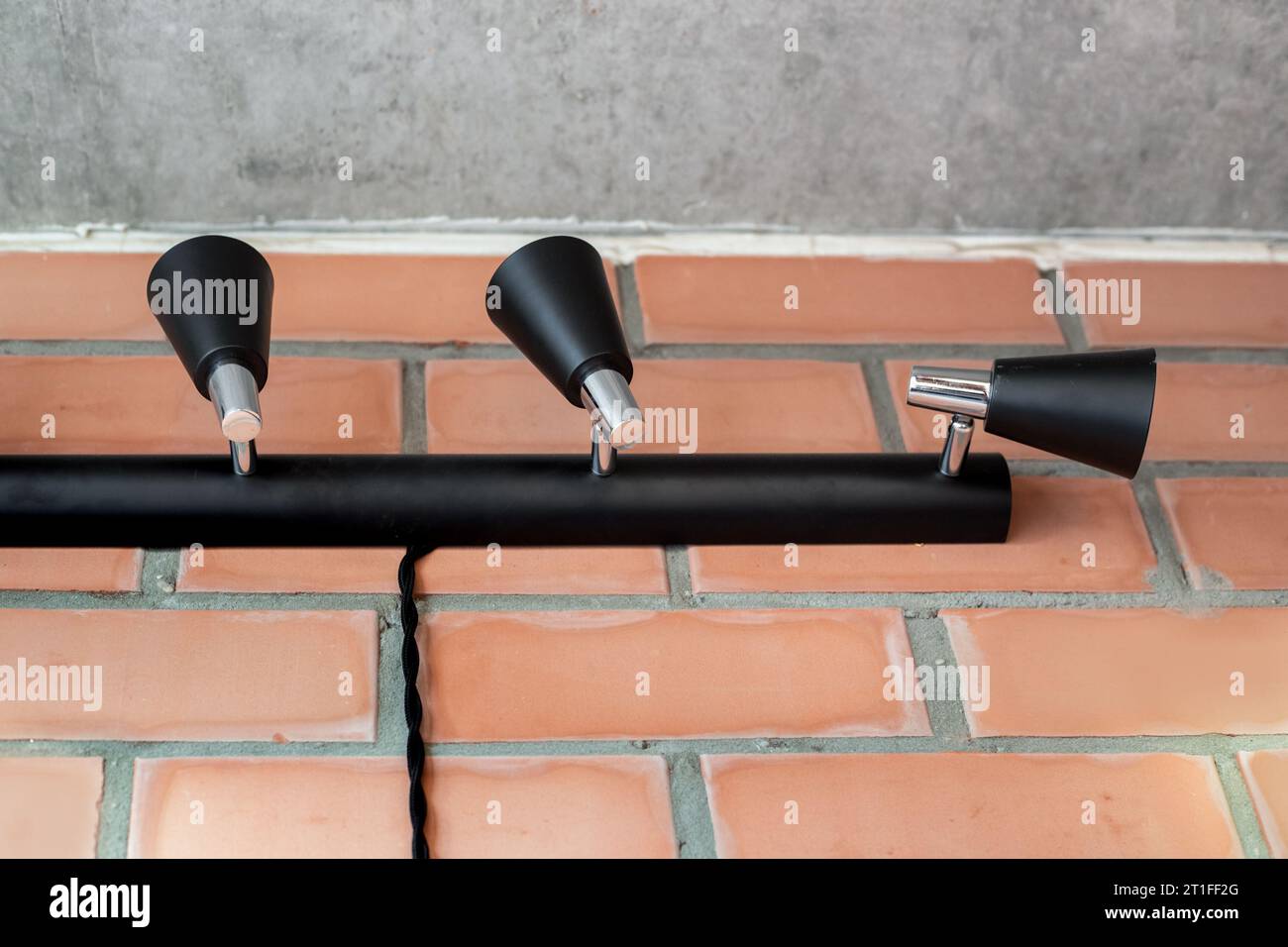 lampes rotatives noires sur une tige noire sur un mur de briques. Conception de l'éclairage. Banque D'Images