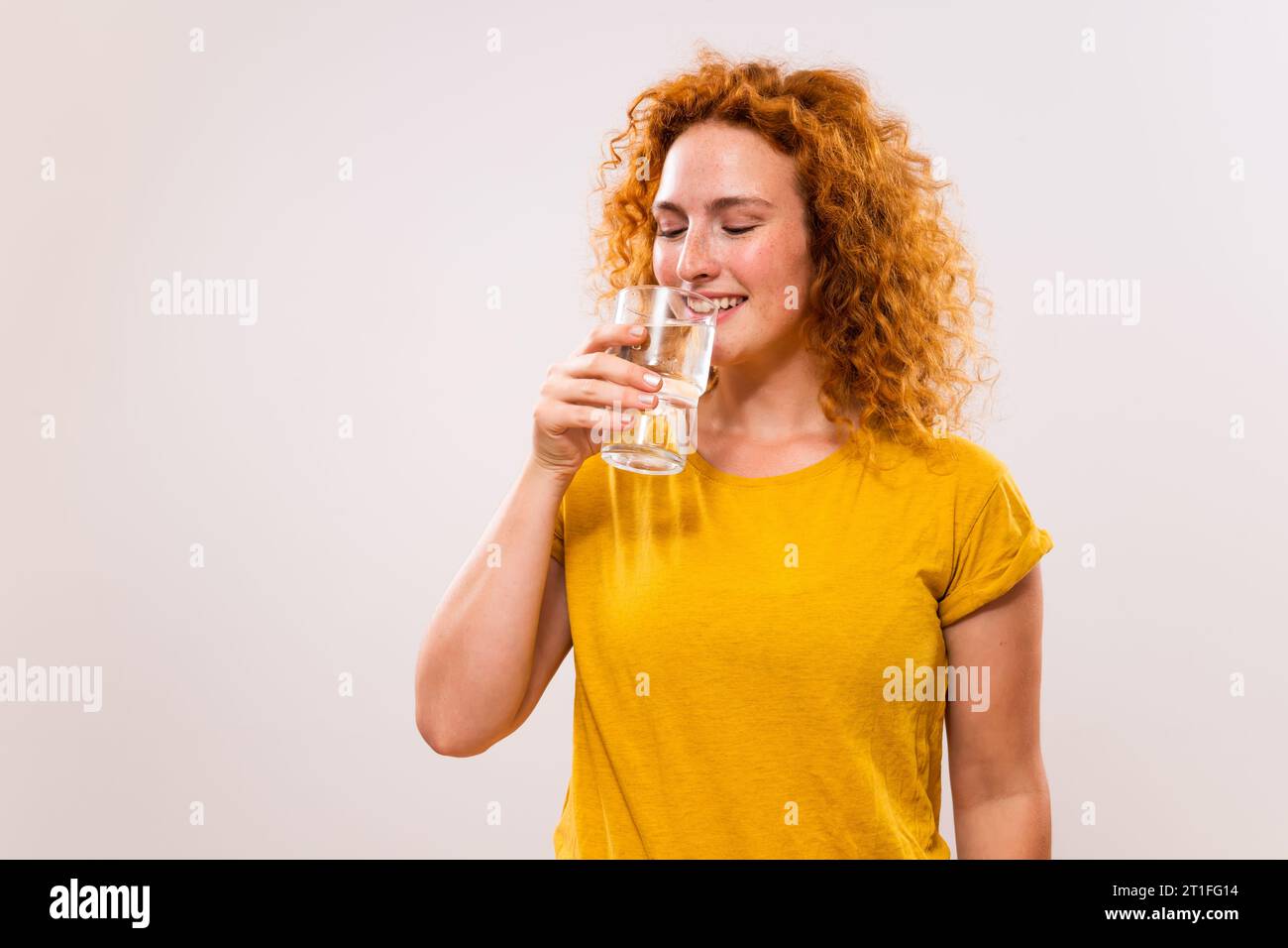 Image de belle femme de gingembre buvant de l'eau. Banque D'Images