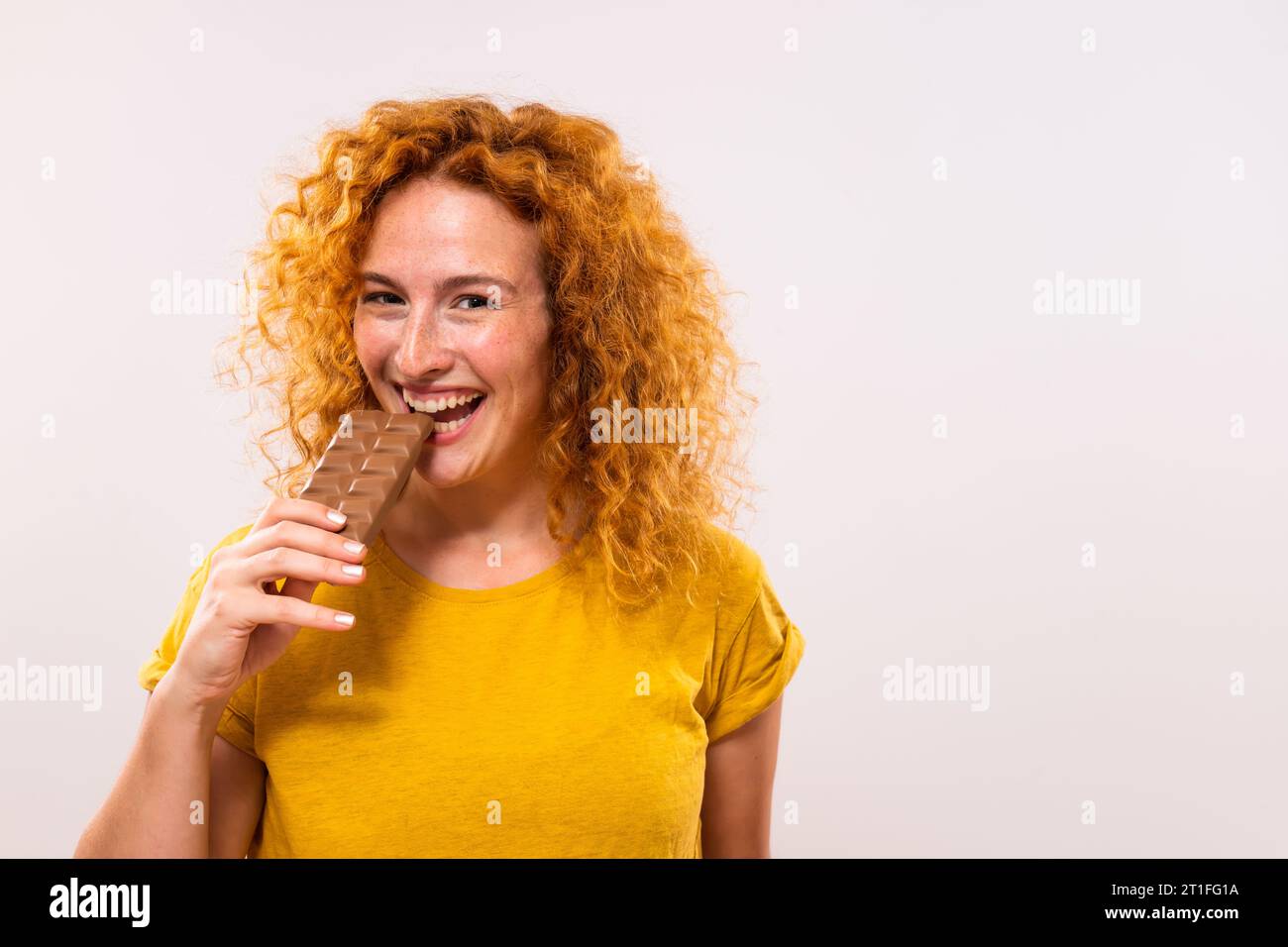 Portrait de femme heureuse mignonne au gingembre aime manger du chocolat. Banque D'Images