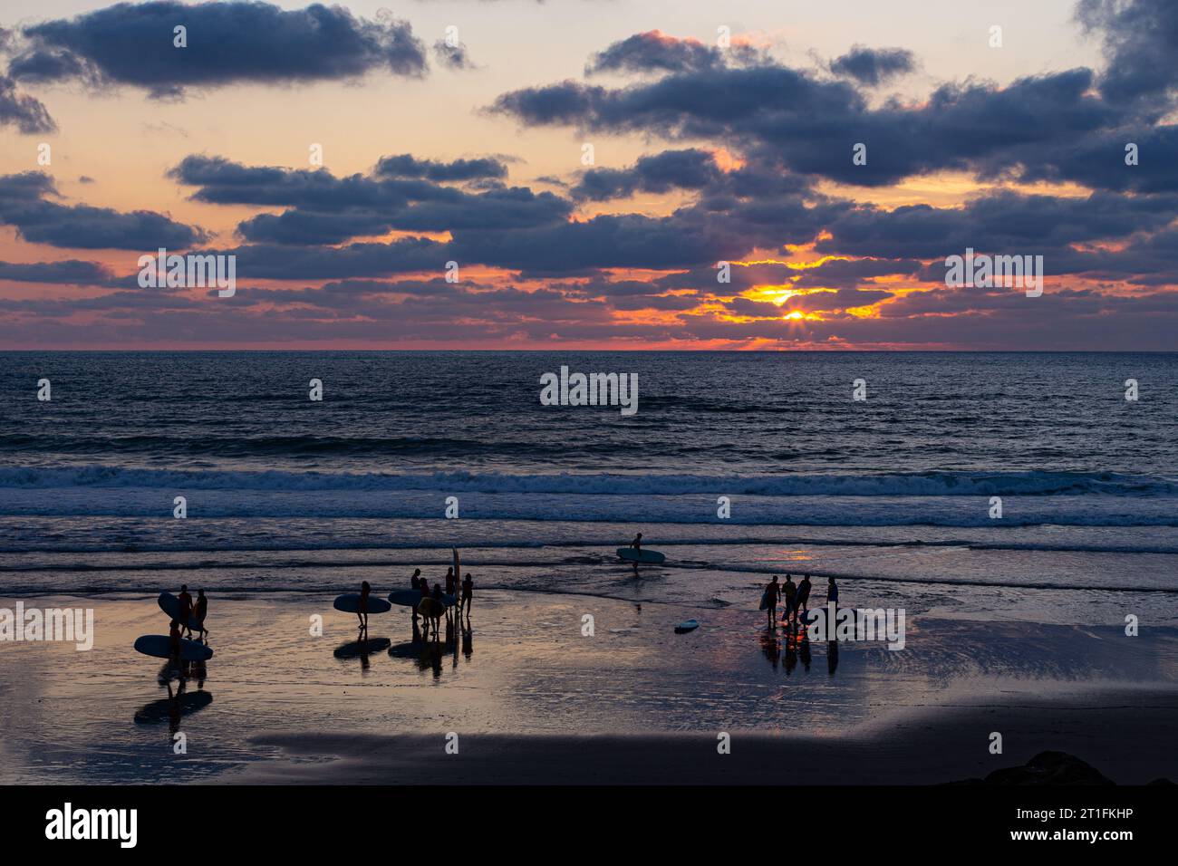 Groupes de surfeurs finissant une leçon de surf au coucher du soleil à Anglet, France Banque D'Images