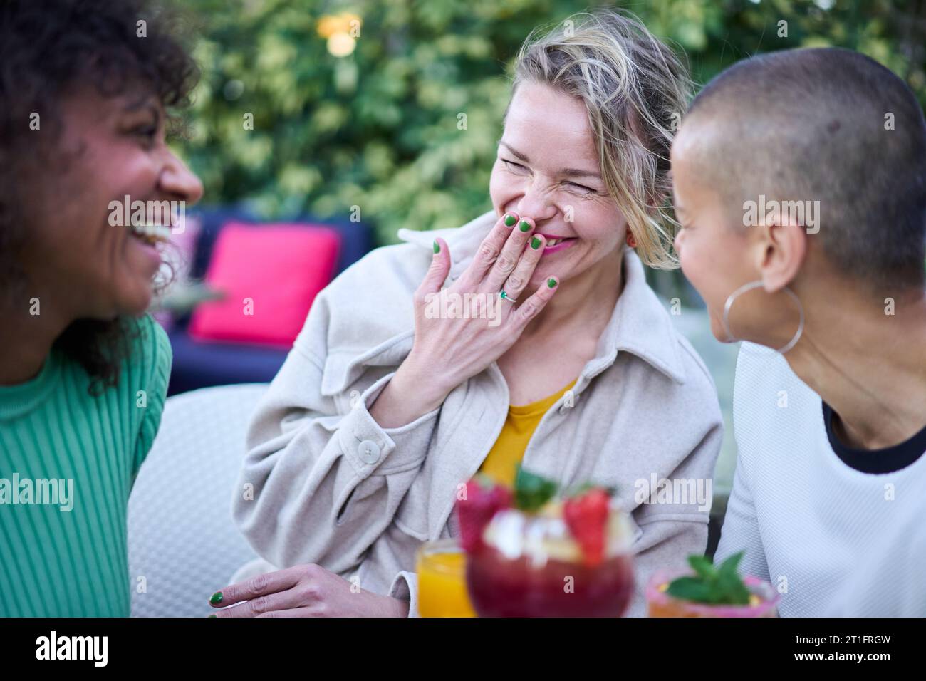 Trois femmes multiraciales mûres riant célébrant la réunion en plein air. Meilleurs amis qui s'amusent. Banque D'Images