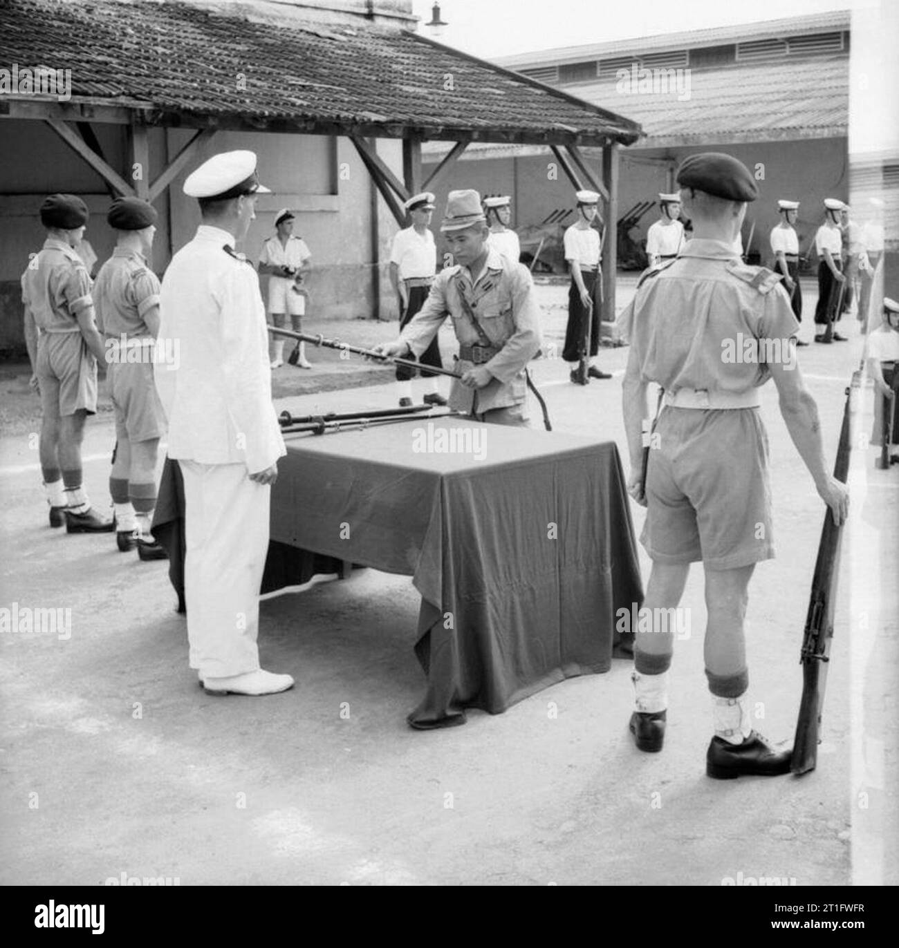 L'occupation alliée de l'Indo-chine française un adjudant de la marine japonaise remet son épée à sous-lieutenant Anthony Martin lors d'une cérémonie à Saigon. Banque D'Images