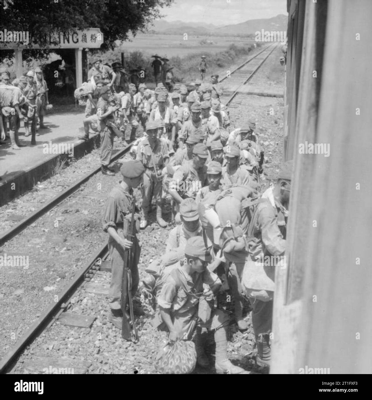 La réoccupation britannique de Hong Kong, 1945 soldats japonais qui ont été arrêtés dans les Fan Ling district de Hong Kong par les hommes de la 3e Brigade Commando sont mis à bord d'un train à destination d'Kowloon . Banque D'Images
