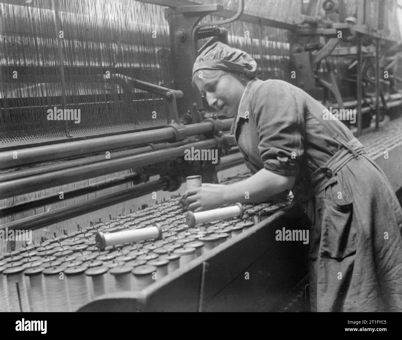 L'industrie au cours de la Première Guerre mondiale- Leicestershire remplace un travailleur féminin des bobines de fil vides dans un rideau de dentelle machine dans une usine de Nottingham en septembre 1918. Banque D'Images