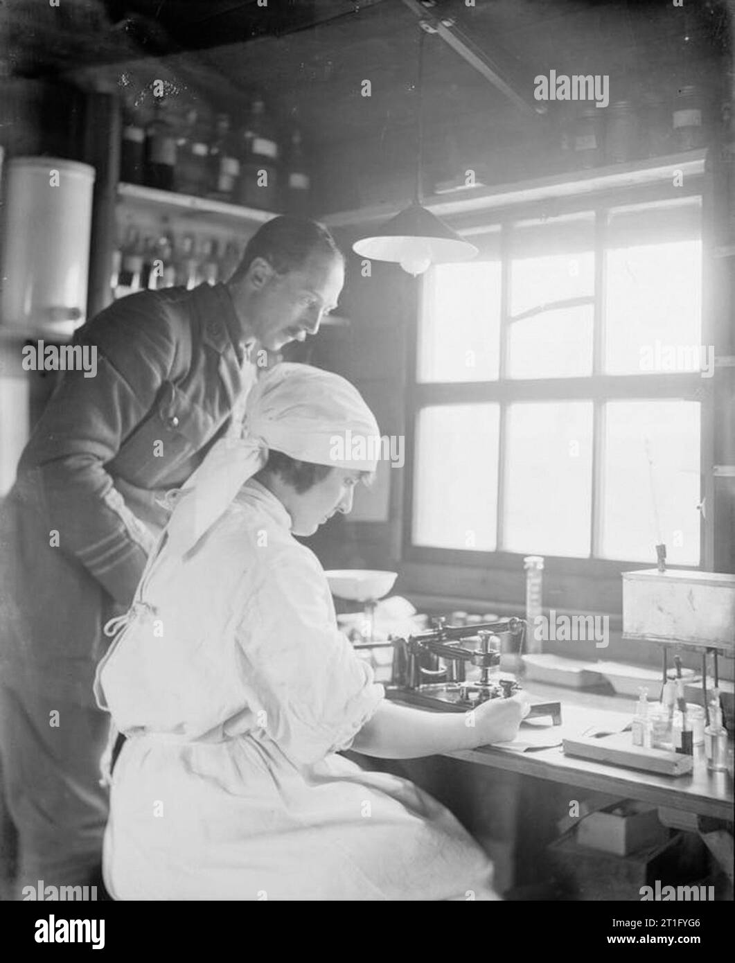 L'Edis Olive, photographe de l'IWM Women's Services en France 1919, un médecin et une infirmière de l'armée (le Dr Patterson et Mlle Nord) travaillant à couper une section pour le test à un banc au 25e hôpital stationnaire à Rouen. Banque D'Images