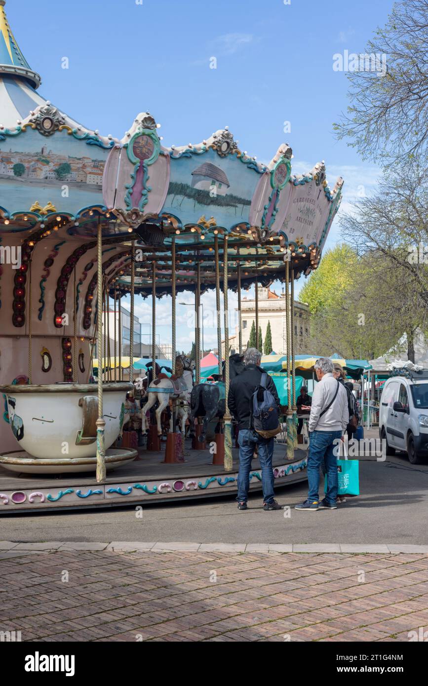 Les amateurs de marché en conversation à côté du joyeux des enfants au marché en plein air du samedi à Arles, Provence, sud de la France. Banque D'Images