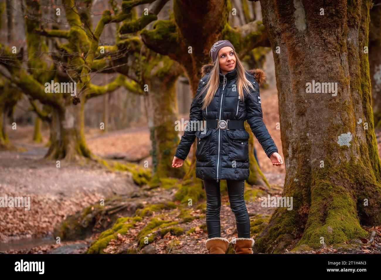 Une jeune femme heureuse dans un arbre dans la forêt d'Otzarreta dans le parc naturel de Gorbea, Bizkaia. Pays Basque. Session Lifestyle Banque D'Images