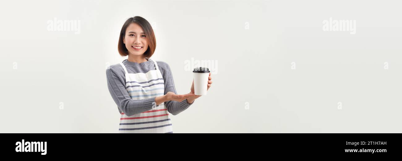 jeune femme en tablier tient deux gobelets de papier à emporter isolés sur fond blanc Banque D'Images