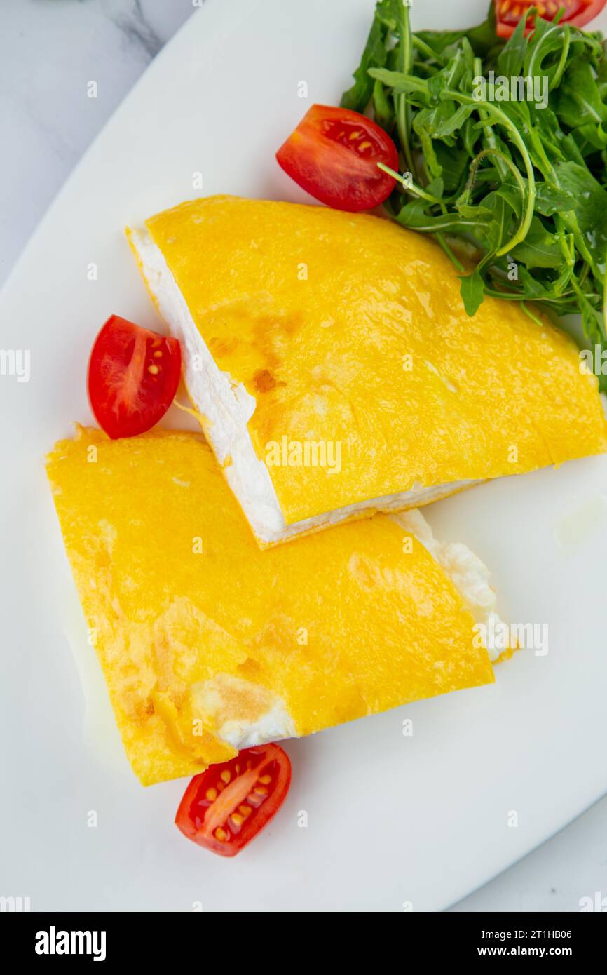 Grande omelette française avec roquette et tomates cerises vue de dessus Banque D'Images