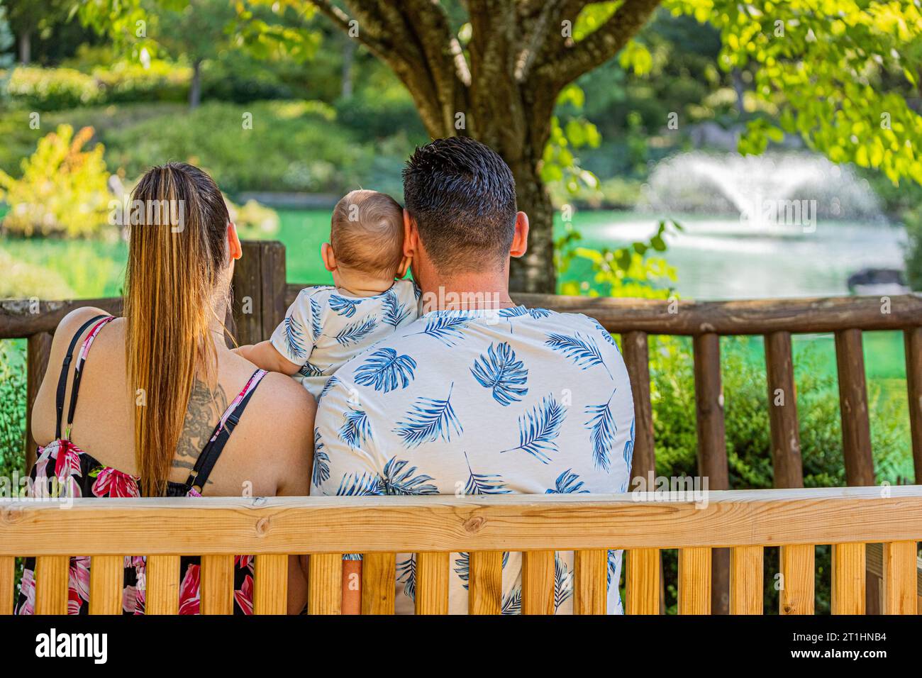 Une famille dans le jardin japonais de Dijon, un couple avec un bébé assis sur un banc. Le jardin japonais à Dijon en famille, couple avec un bébé assis sur un Banque D'Images