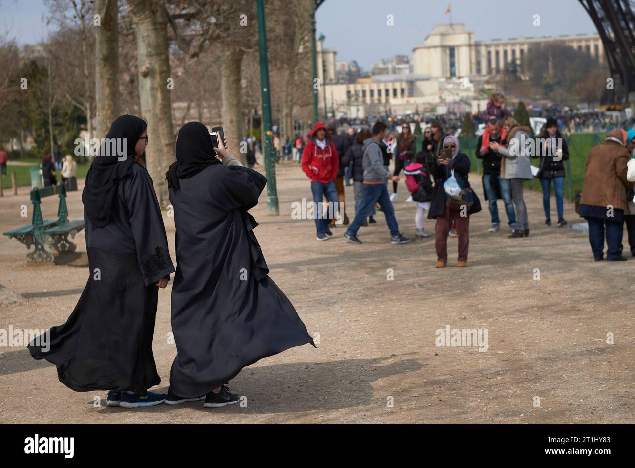 Deux femmes arabes prenant des photos sous la Tour Eiffel Banque D'Images