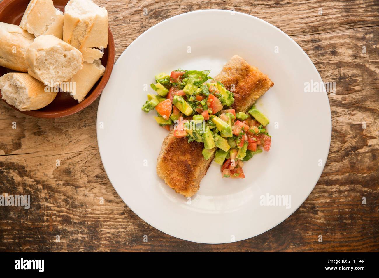Le filet cuit et frit d'un chien lisse étoilé, Mustelus asterias, pêché dans la Manche, qui a été servi avec un avocat et une tomate Banque D'Images