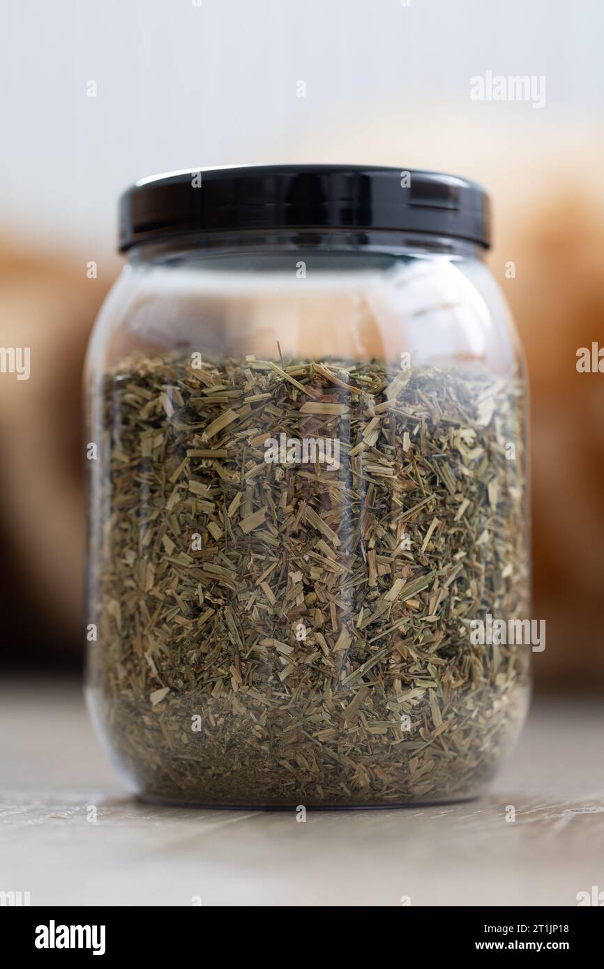 Portrait d'un pot en plastique ou d'un pot plein de feuilles tricolores d'alto fraîches séchées pour préparer une tasse de thé fraîche. Les herbes sont prêtes à être utilisées dans un W relaxant Banque D'Images