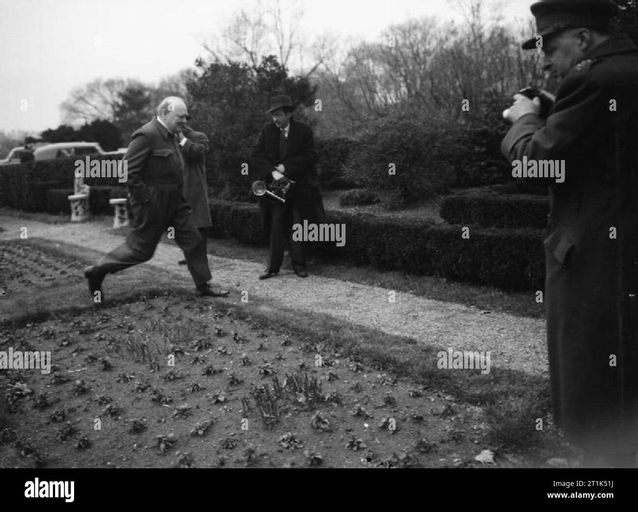 Winston Churchill à Washington au cours de sa "mission de l'Amérique", janvier 1942, M. Churchill, vêtu de son costume de sirène caractéristique, pas délibérément sur la pelouse à la Maison Blanche, Washington DC. Il est vu par le cinéma et les photographes. Banque D'Images