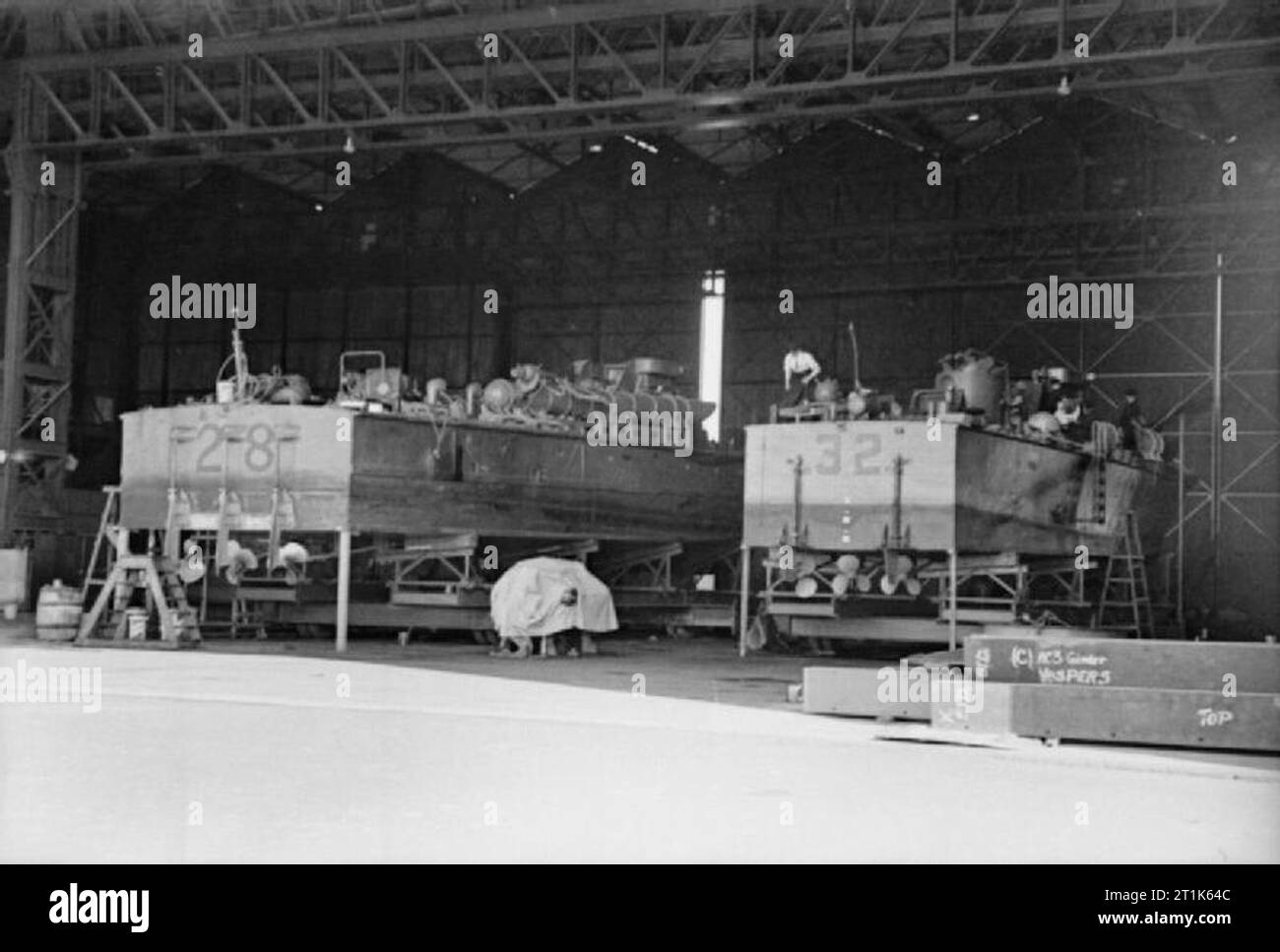 Du VTT à Felixstowe. 1940. Deux torpilleurs à moteur type Vosper MTB MTB, 28 et 32, de la 4e Flottille de vedettes lance-torpilles sur les stands dans le hangar à HMS Beehive, Felixstowe, Suffolk. Banque D'Images