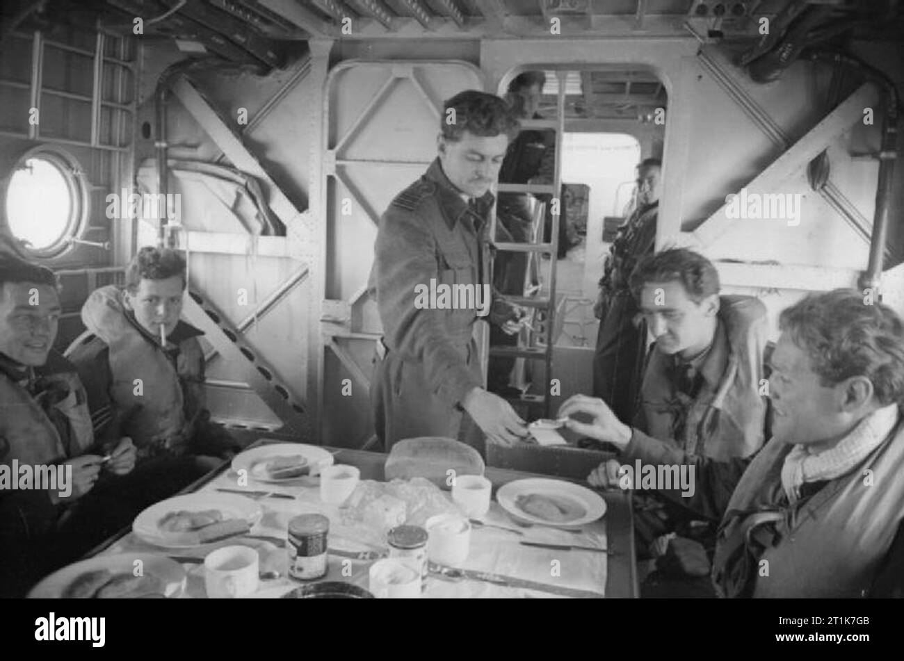 Royal Air Force 1939-1945- Coastal Command le 13 juillet 1942 un Sunderland du nouvel escadron 461 aucun aucun 77 RAAF a sauvé un équipage de l'Escadron Whitley, dans le golfe de Gascogne. Le capitaine du Sunderland était le commandant de l'Escadre, Neville Halliday, vu ici donner des cigarettes à son soulagé et affamés de nouveaux passagers dans une reconstitution officielle qui a eu lieu à Mount Batten au profit d'un photographe officiel. Banque D'Images