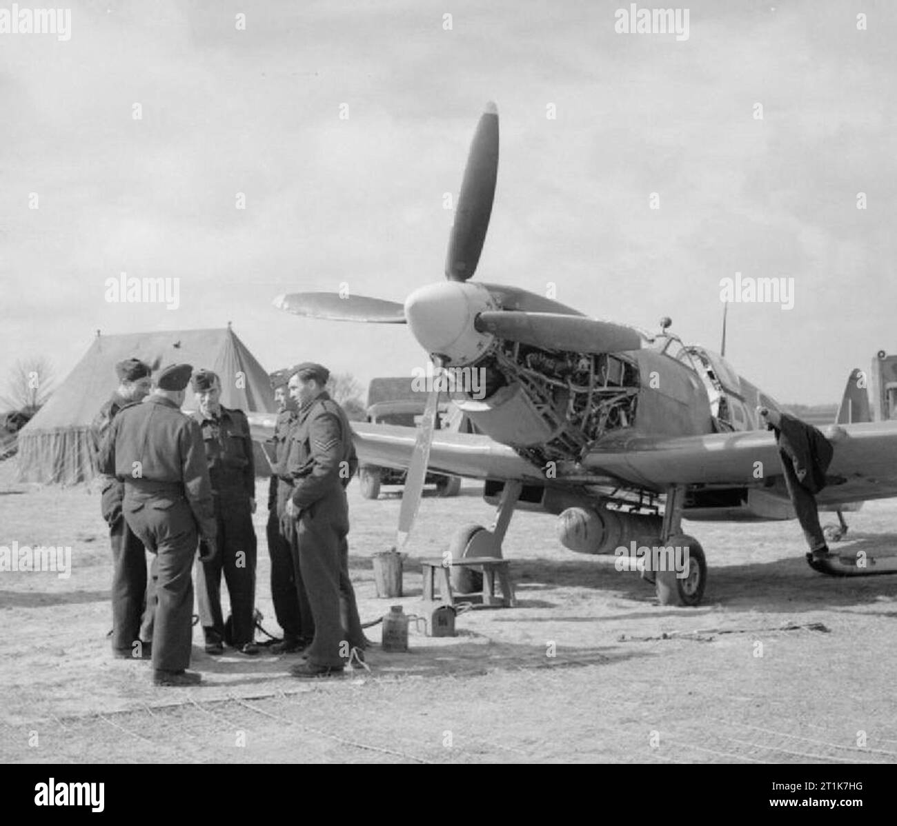 Royal Air Force 1939-1945- le Fighter Command un Spitfire LF IX de l'Escadron 313 pas l'objet d'un changement d'huile à l'ALG Appledram (advanced landing ground), à Corsier (GE), 19 avril 1944. De nombreux escadrons de combat ont été exploités à partir de bandes temporaires dans le sud de l'Angleterre, leurs pilotes et l'entretien ci-joint s'habituer à l'échelle 'à la dure' dans l'open en préparation d'un déploiement futur sur le continent. Les trois escadrons de Spitfire de personnel tchèque opérations d'escorte de vol Appledram à ce moment (Nos 310, 312 et 313) font partie du groupe no 84, 2nd Tactical Air Force. Banque D'Images
