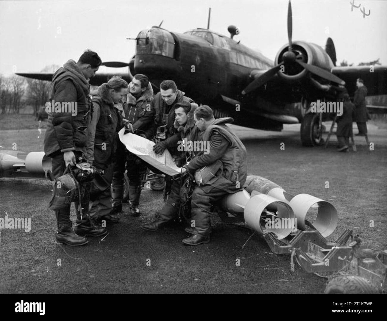 Royal Air Force Bomber Command, 1939-1941. L'équipage d'un bombardier de No 311 (Escadron tchécoslovaque) étude de la RAF une carte, tout en étant assis sur des bombes de 250 lb GP, qui sont sur le point d'être chargés dans leur Mark Vickers Wellington IC à l'East Wretham, Norfolk. Banque D'Images