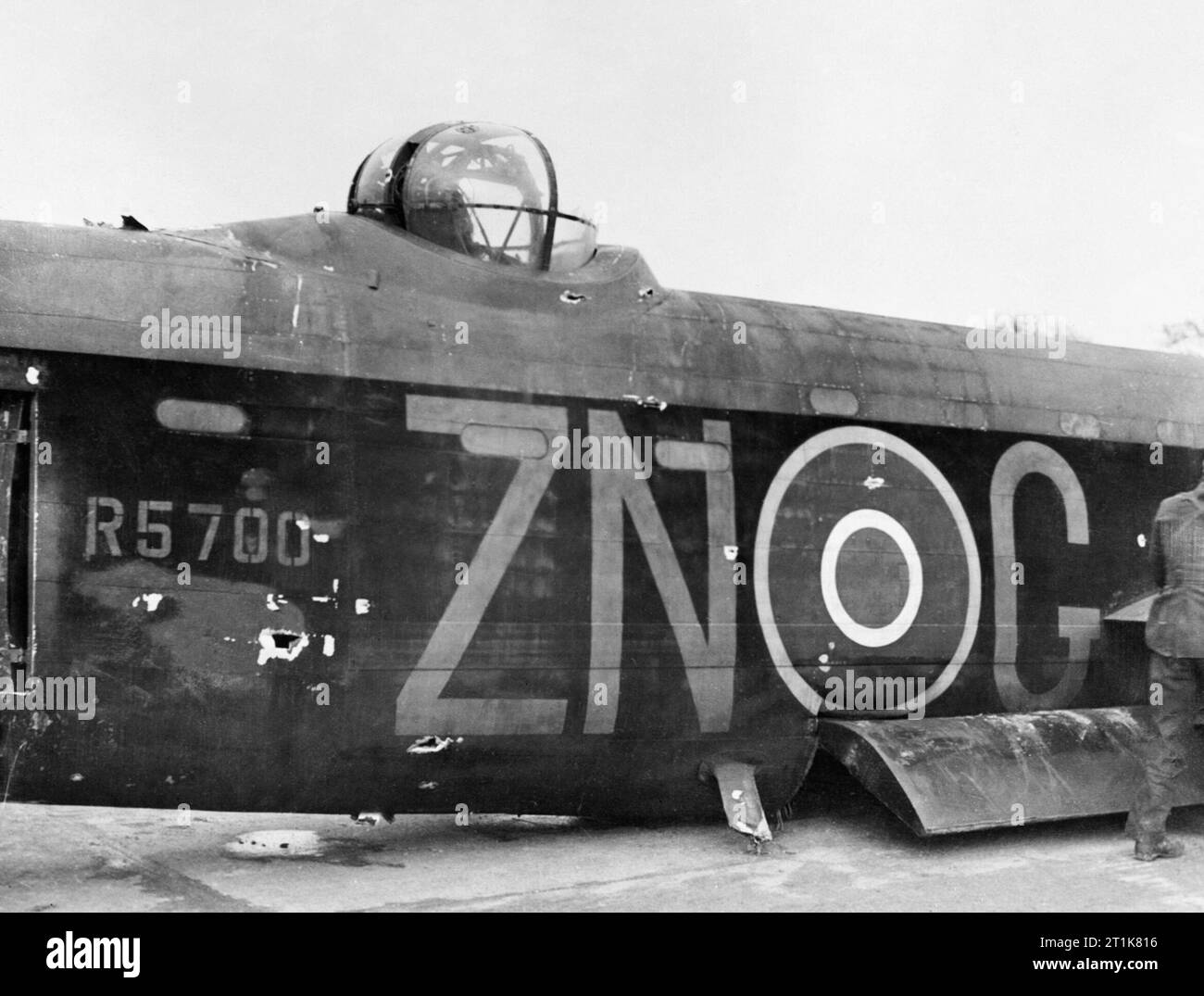 Royal Air Force Bomber Command, 1942-1945. Le fuselage endommagé et tourelle centre supérieure de Avro Lancaster B Mark I, R5700 'ZN-G', du no 106 Squadron RAF basés à Elsham Wolds, Lincolnshire, après l'atterrissage à Hardwick, Norfolk, à la suite d'une attaque d'un chasseur allemand sur Essen. R5700, a été parmi les 60 avions qui participent à la première 'Oboe' raid sur Berlin dans la nuit du 13/14 janvier 1943, lorsqu'il a été attaqué par deux fois un Focke Wulf Fw 190 'Wilde Sau' night-fighter peu après l'attentat à la cible. L'avion a été gravement endommagé, le mitrailleur arrière a été grièvement blessé et le mitrailleur dorsal, se Banque D'Images