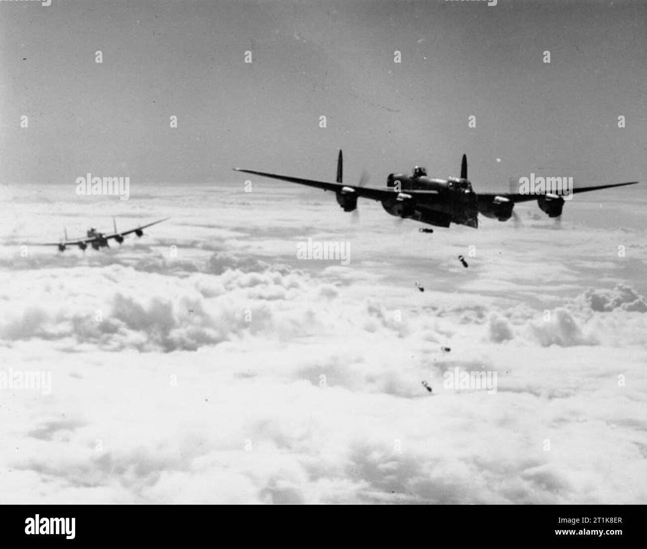 Royal Air Force Bomber Command, 1942-1945. L'Avro Lancaster B Mark I ou III du No 514 Squadron RAF basés à Waterbeach, Cambridgeshire, presse ses bombes à travers les nuages, la lumière du jour au cours d'une attaque sur un site de lancement de la bombe volante à Les Catelliers dans le nord de la France, ('Noball"), comme un autre avion derrière elle se prépare à bombarder. Banque D'Images