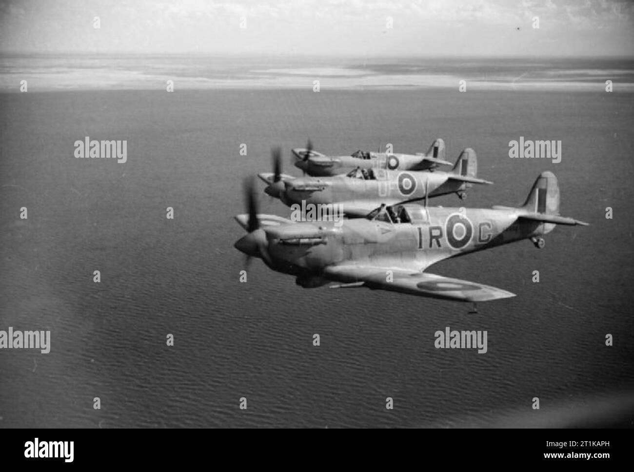 Opérations de la Royal Air Force au Moyen-Orient et en Afrique du Nord, 1939-1943. Trois Spitfire LF Mark VBs de No 244 RAF Wing basé à Bu Grara, volant en formation echelon tribord au large de la côte tunisienne après l'escorte des bombardiers légers sur une sortie de Mareth. AB502-G 'IR', au premier plan, est l'avion personnel du Chef d'Escadre, commandant de l'Escadre J R 'Large' Gleed, qu'il a effectué lorsqu'il a été abattu et tué plus de Cap Bon le 16 avril 1943, alors que les deux avions d'accompagnement sont ER220 'UF-V' et 'UF EP481-F' de No 601 Squadron RAF. Tous les trois sont équipés de filtres à air d'Aboukir et ont Banque D'Images