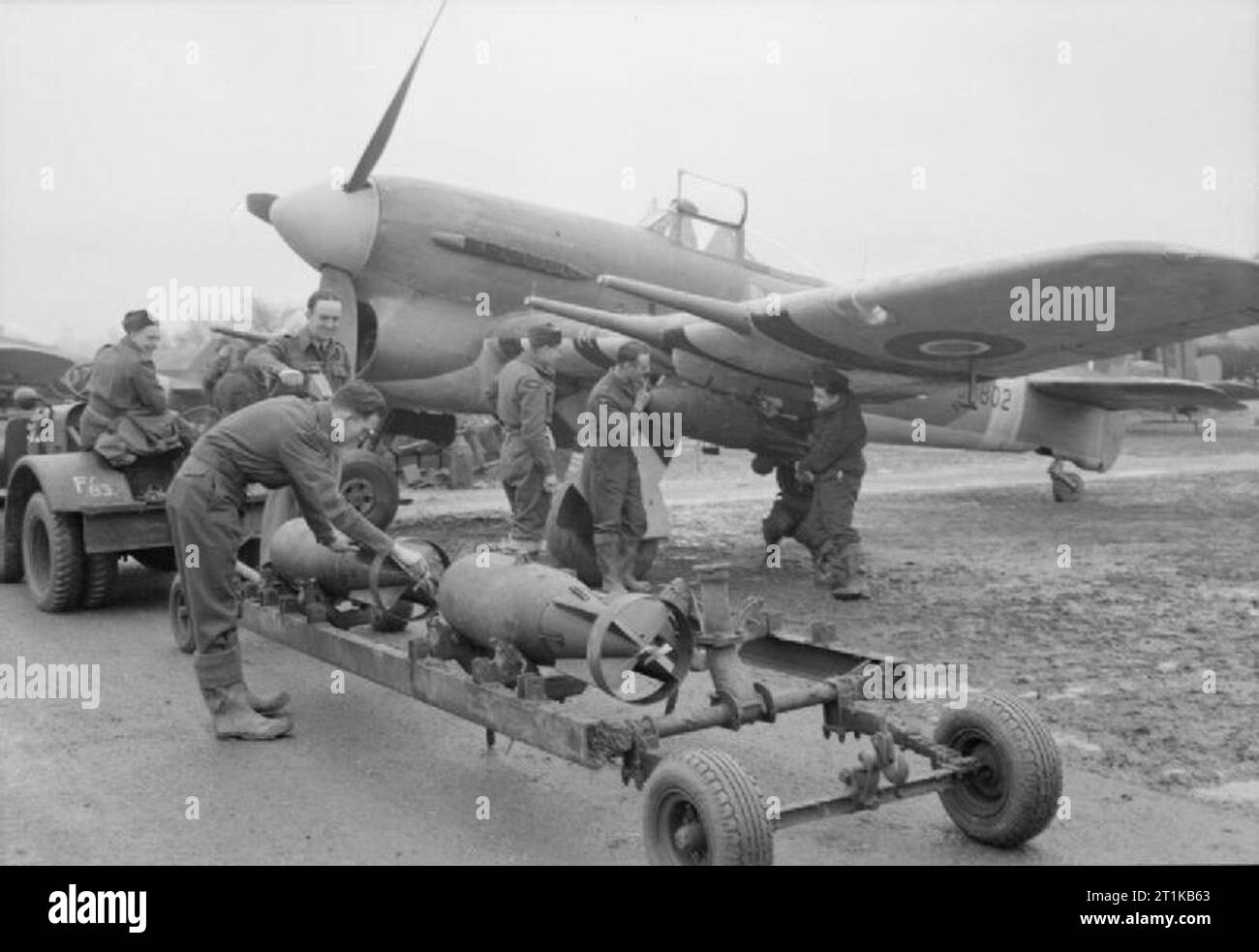 Royal Air Force- 2nd Tactical Air Force, 1943-1945. Les armuriers 500-lb raccord à bombes MC Marque Hawker Typhoon IB, JP802 'MR-M', du no 245 Squadron RAF à Westhampnet, Sussex, pour qu'une attaque sur un site de lancement de la bombe volante dans le nord de la France ('Noball"). Banque D'Images