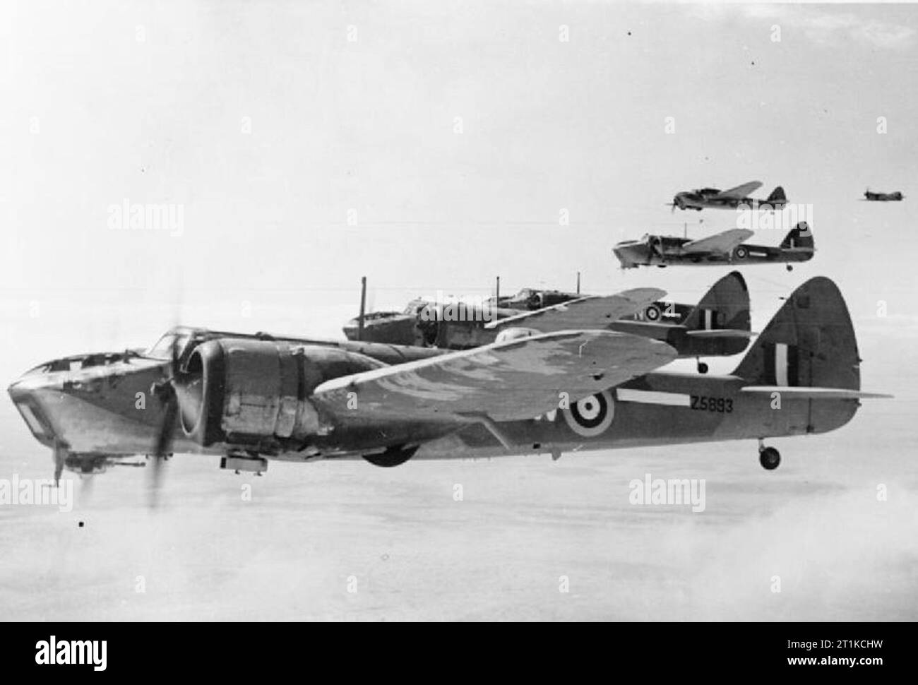 Les avions de la Royal Air Force 1939-1945- Bristol Blenheim IV Type Type 149. Une formation de cinq Blenheim Mark IVs (Z5893 'W') plus proche du No 14 Squadron RAF en vol au dessus de l'ouest du désert. Un Curtiss Kittyhawk, l'un des chasseurs d'escorte, peut être vu sur l'extrême droite. Banque D'Images