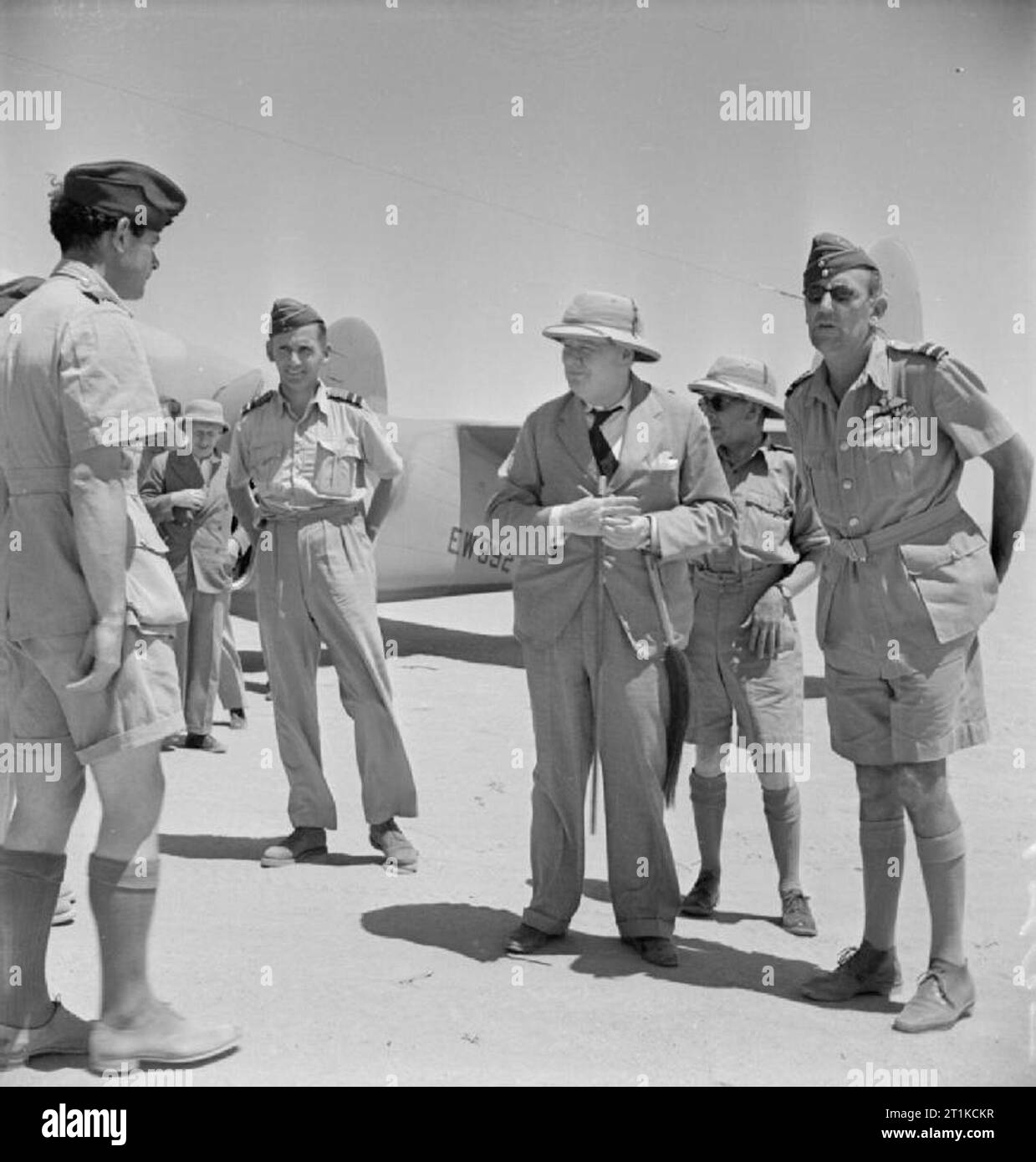 Royal Air Force- les opérations au Moyen-Orient et en Afrique du Nord, 1940-1943. Le premier ministre Winston Churchill, accompagné de l'Air Chief Marshal Sir Arthur Tedder, Commandant de l'air en chef de la Royal Air Force Moyen-orient (commande à gauche de Churchill) et le vice-maréchal de l'air Arthur 'Mary' Coningham, Commandant de l'air, de l'Administration centrale de l'air désert occidental, (à droite), des pourparlers avec le commandant d'un escadron de la RAF, peu après son arrivée à l'AHQ, Ma'Aton Bagush, pour le déjeuner, au cours de sa visite en Égypte. Un Lockheed Hudson de No 267 Squadron RAF, qui a volé de Churchill et de son parti sur l'h Banque D'Images